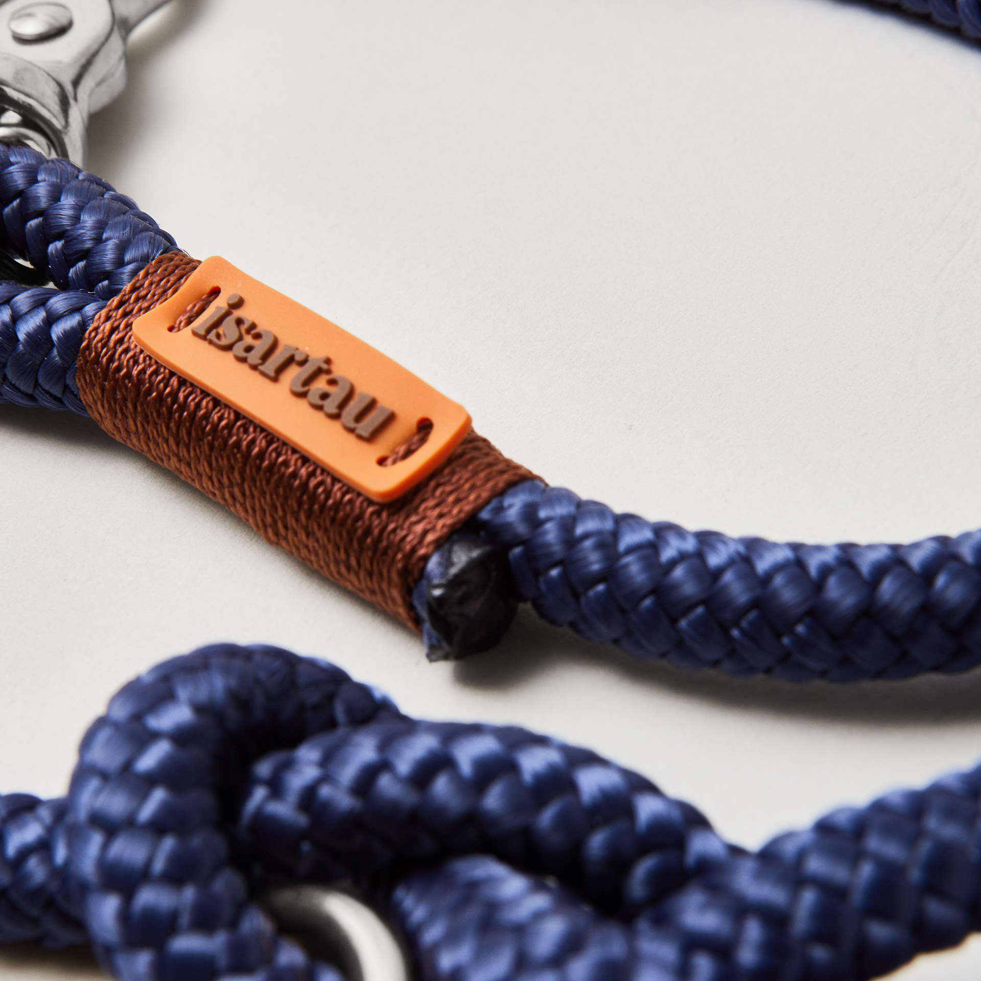 Detail Tauleine Indigo Sea Kastanie, dunkelblaues Tau mit brauner Takelung, Fokus auf silberfarbene Karabiner und Tau