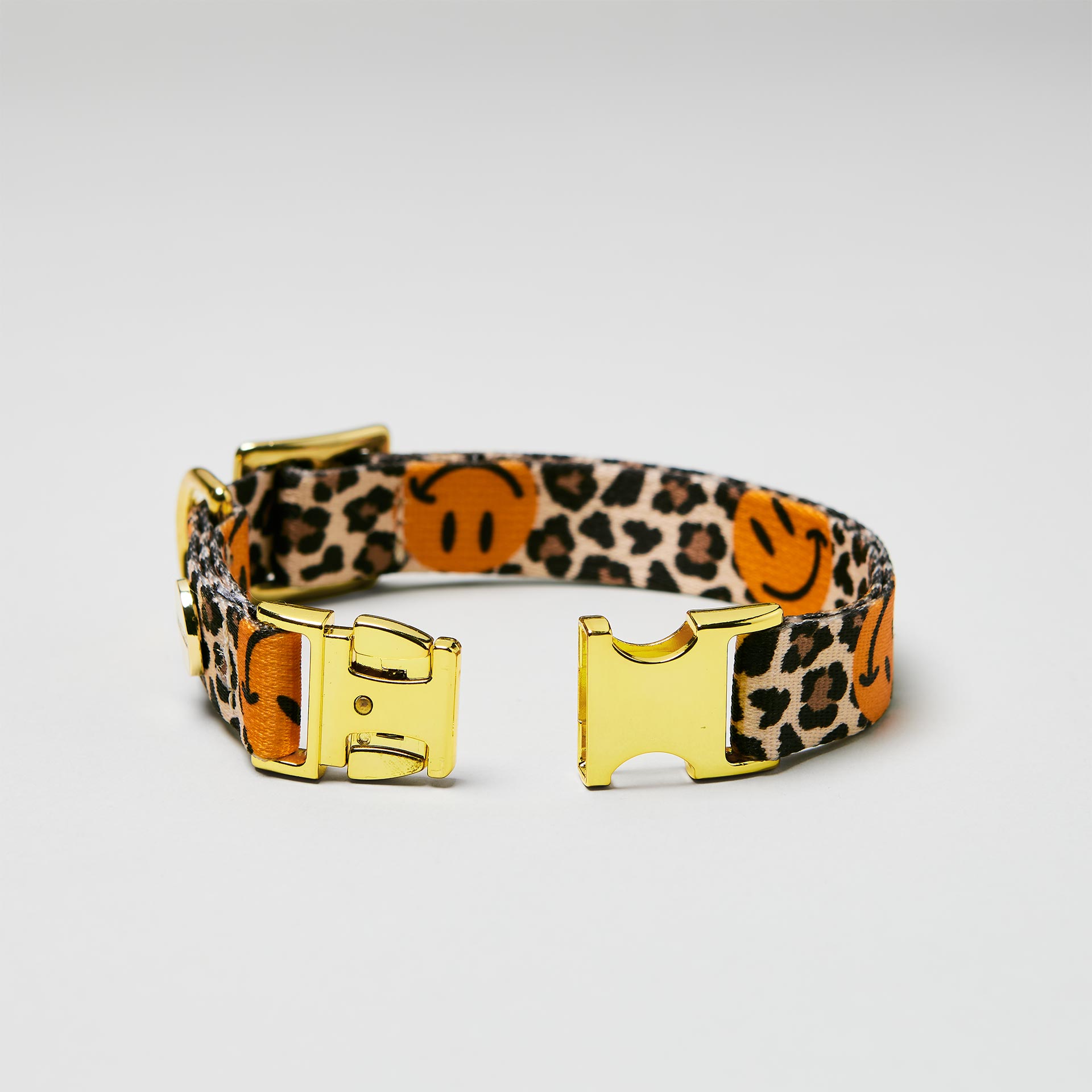 Detailaufnahme verstellbares Welpenhalsband Leo Smile mit offener goldfarbener Steckschließe, Gurtband mit Leoprint