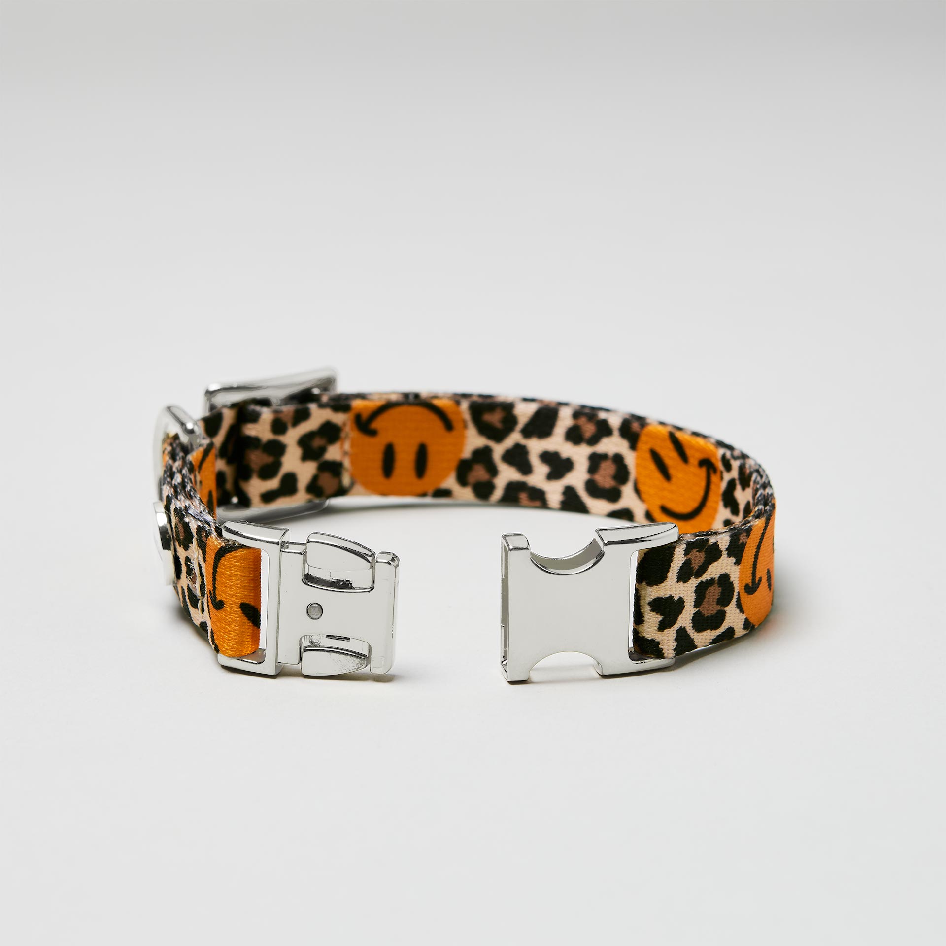 Detailaufnahme verstellbares Welpenhalsband Leo Smile mit offener silberfarbener Steckschließe, Gurtband mit Leo und Smile Motiv