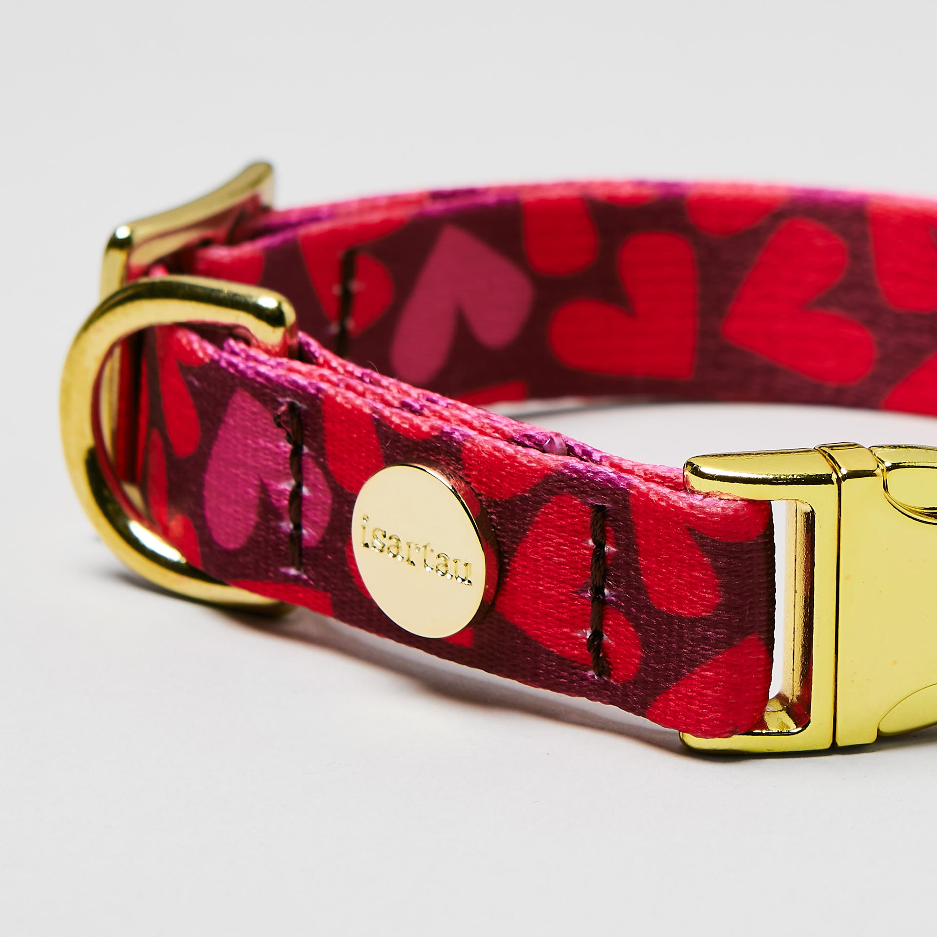 Nahaufnahme verstellbares Welpenhalsband Herzklopfen, Gurtband mit Herzen in Rottönen, goldfarbene Schließe