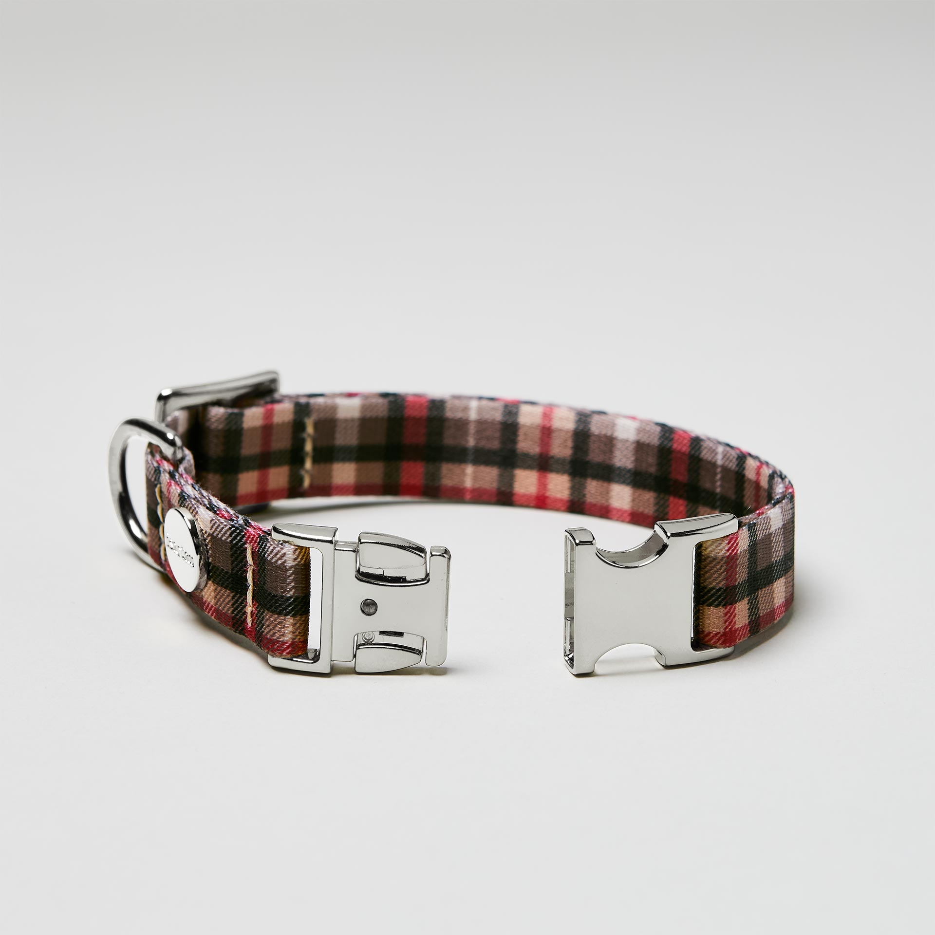 Detailaufnahme verstellbares Hundehalsband „Flaneur“ mit offener silberfarbener Steckschließe, Gurtband mit Karomuster.