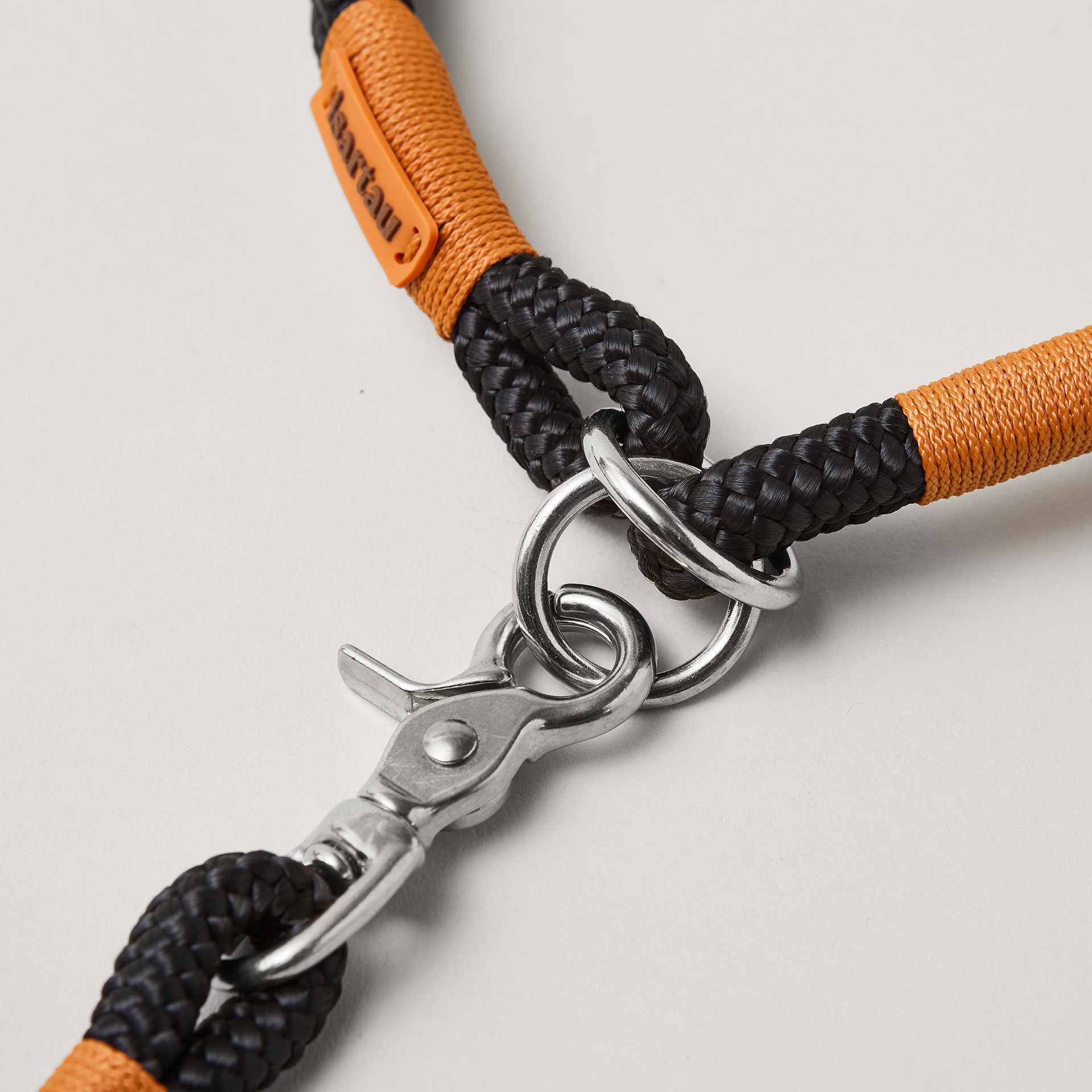 Detail Zugstopp Halsband mit Tauleine Black Mamba Rost Orange, schwarzes Tau mit rost-oranger Takelung Fokus auf silberfarbene Ringe und Karabiner