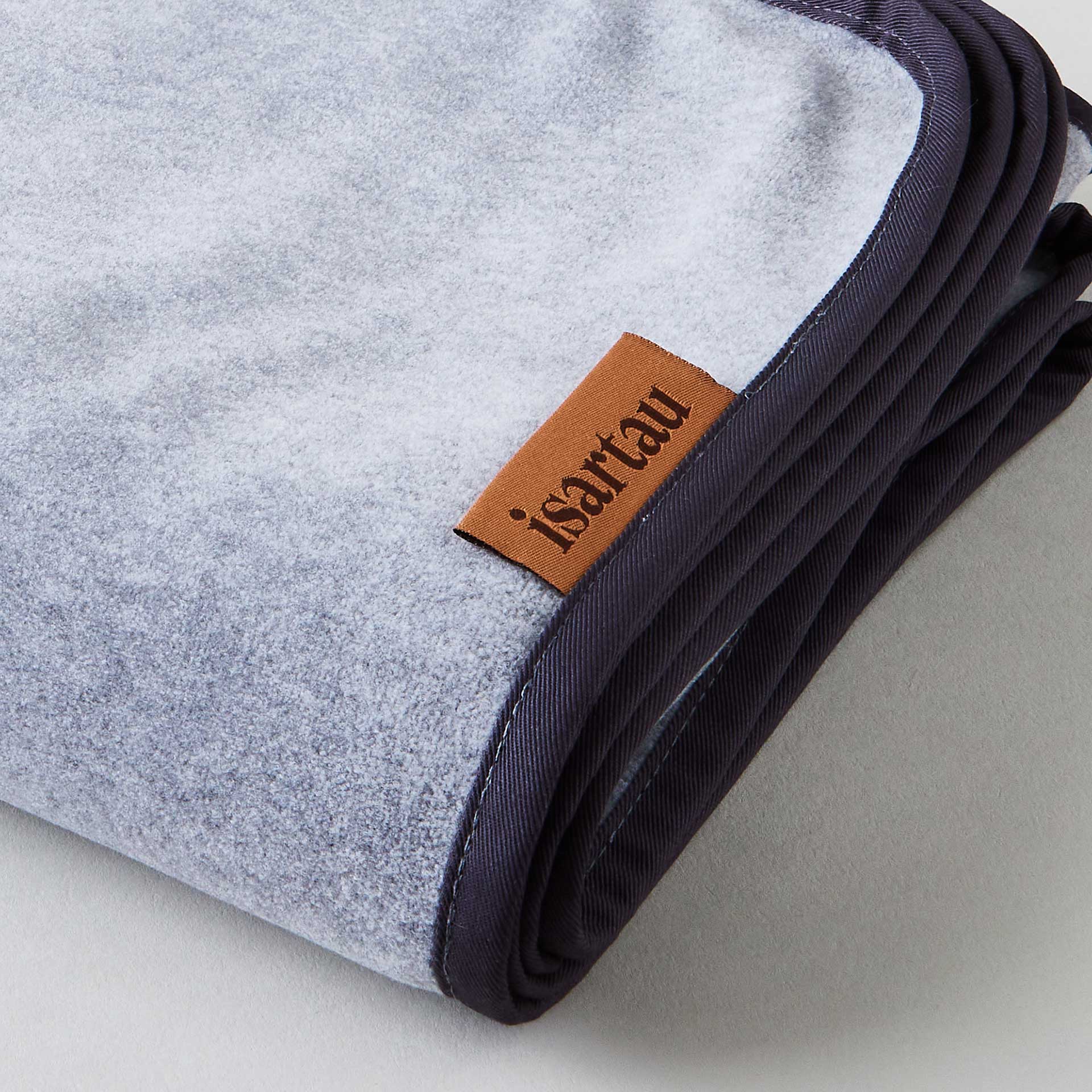 Detailbild Schmusedecke Grau mit dunkelgrauer Einfassung, isartau Logo