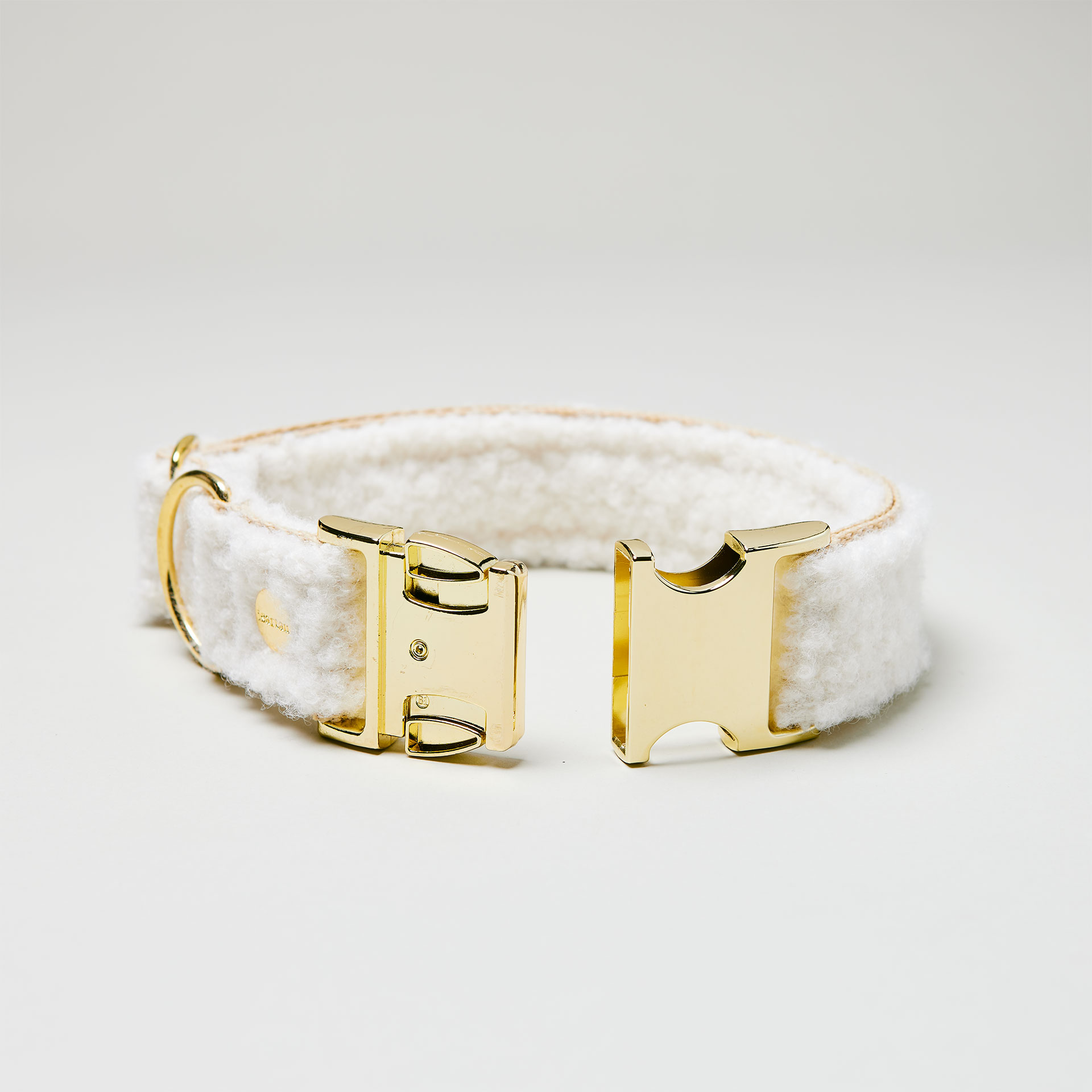 Detailaufnahme verstellbares Hundehalsband Design Wooly mit beigem Gurtband und weißem Bouclé Stoff mit goldfarbener Steckschließe