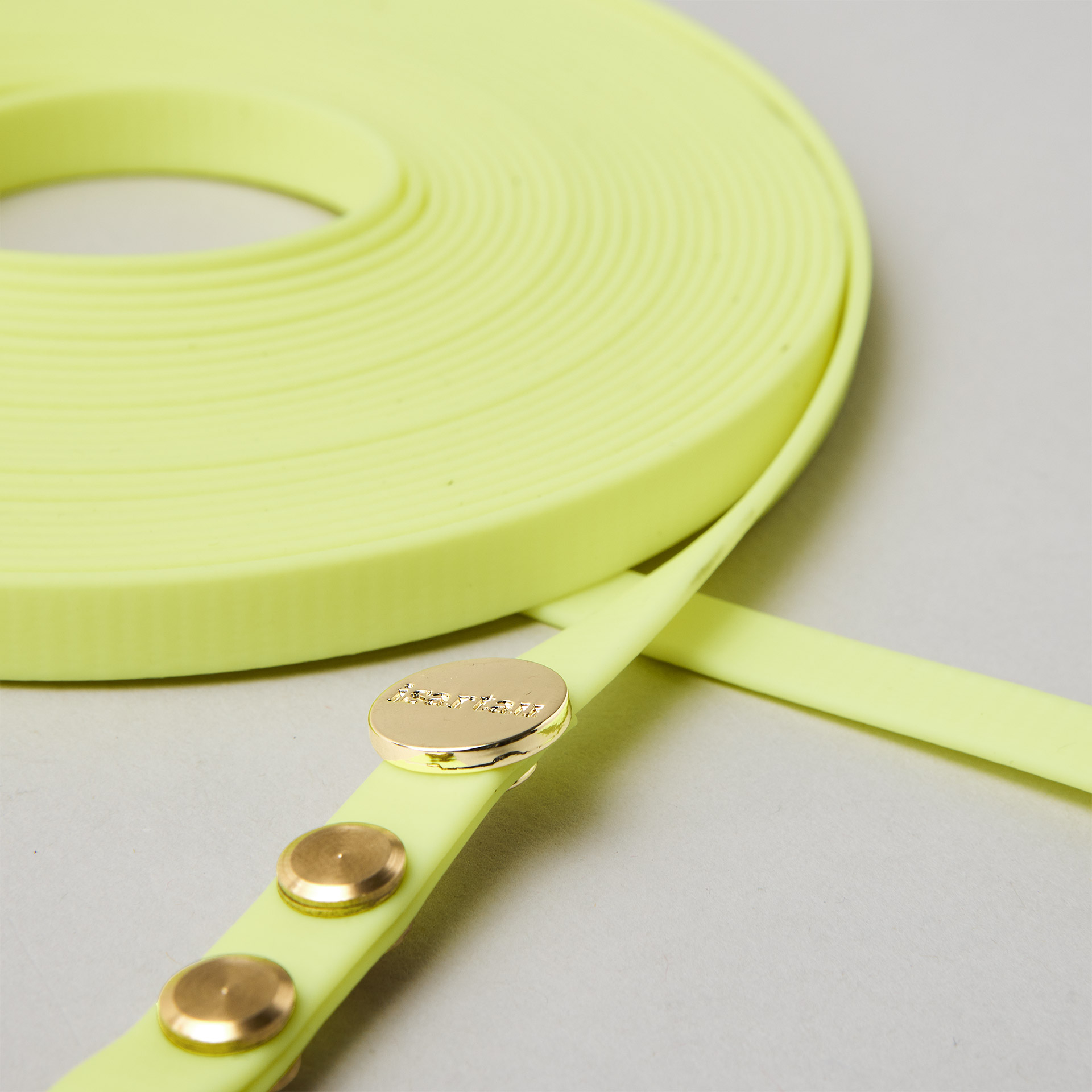 Detail Schleppleine Neongelb, Buchschrauben und Logo goldfarben