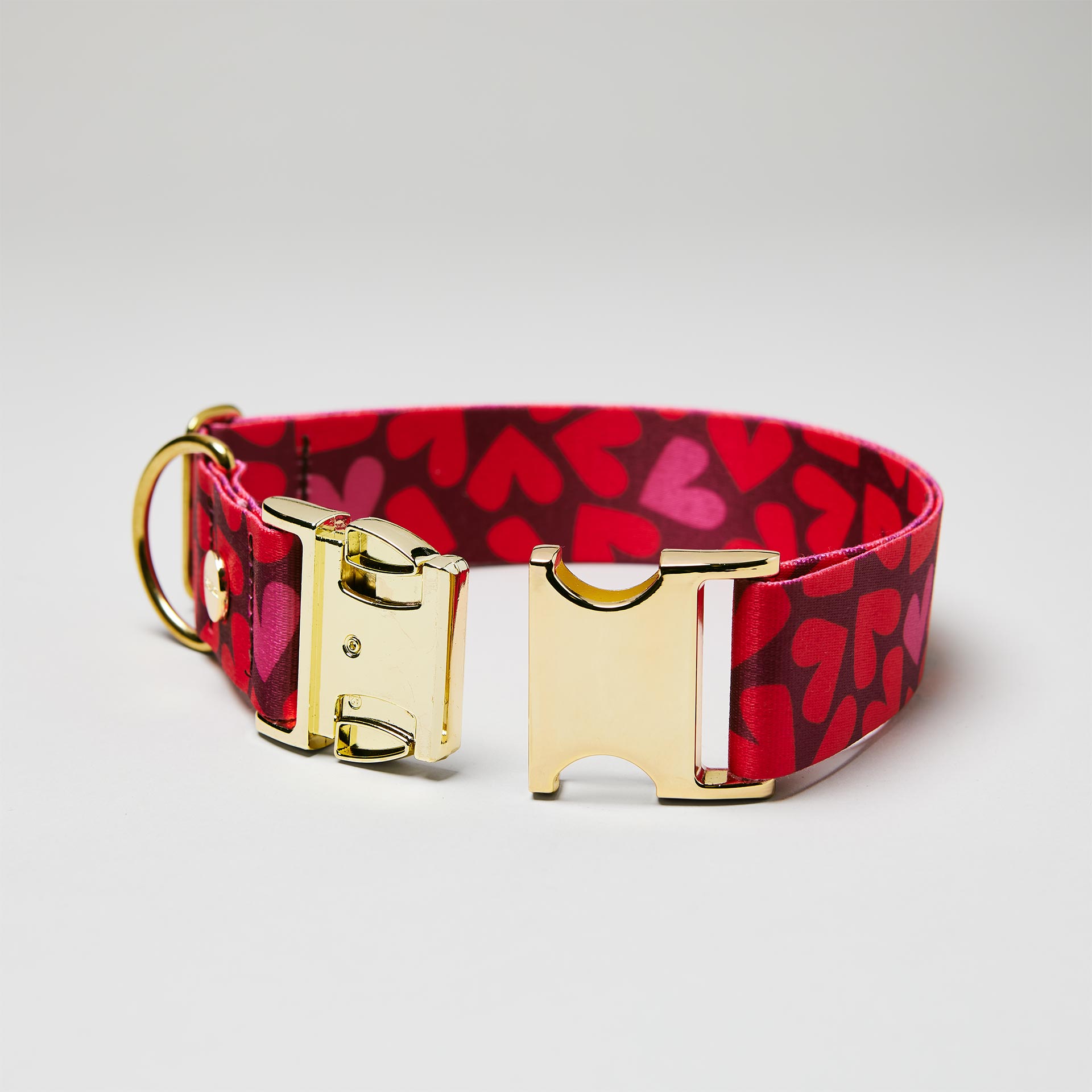 Detailaufnahme verstellbares Halsband Herzklopfen mit offener goldfarbener Steckschließe, Motiv mit roten Herzen