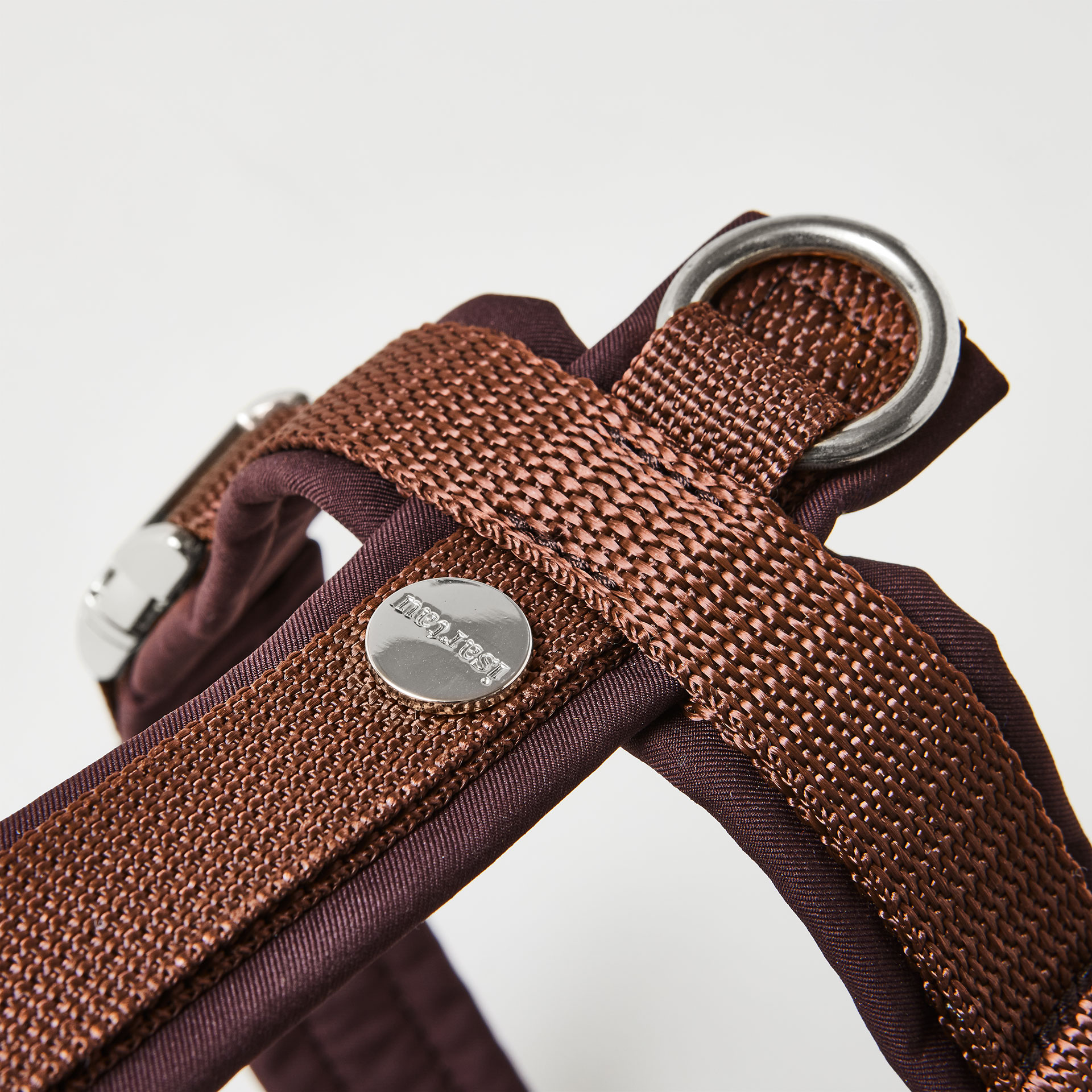 Rückenstück des dunkelbraunen Hundegeschirrs mit gepolstertem O-Ring zum Einhaken des Karabiners und Logo-Niete