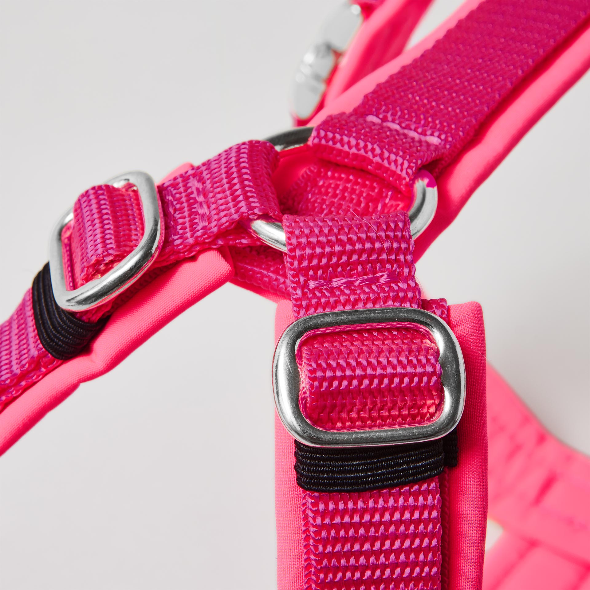 Silberfarbene verstellbare Schieber im Schulterbereich des neonpinken Hundegeschirrs
