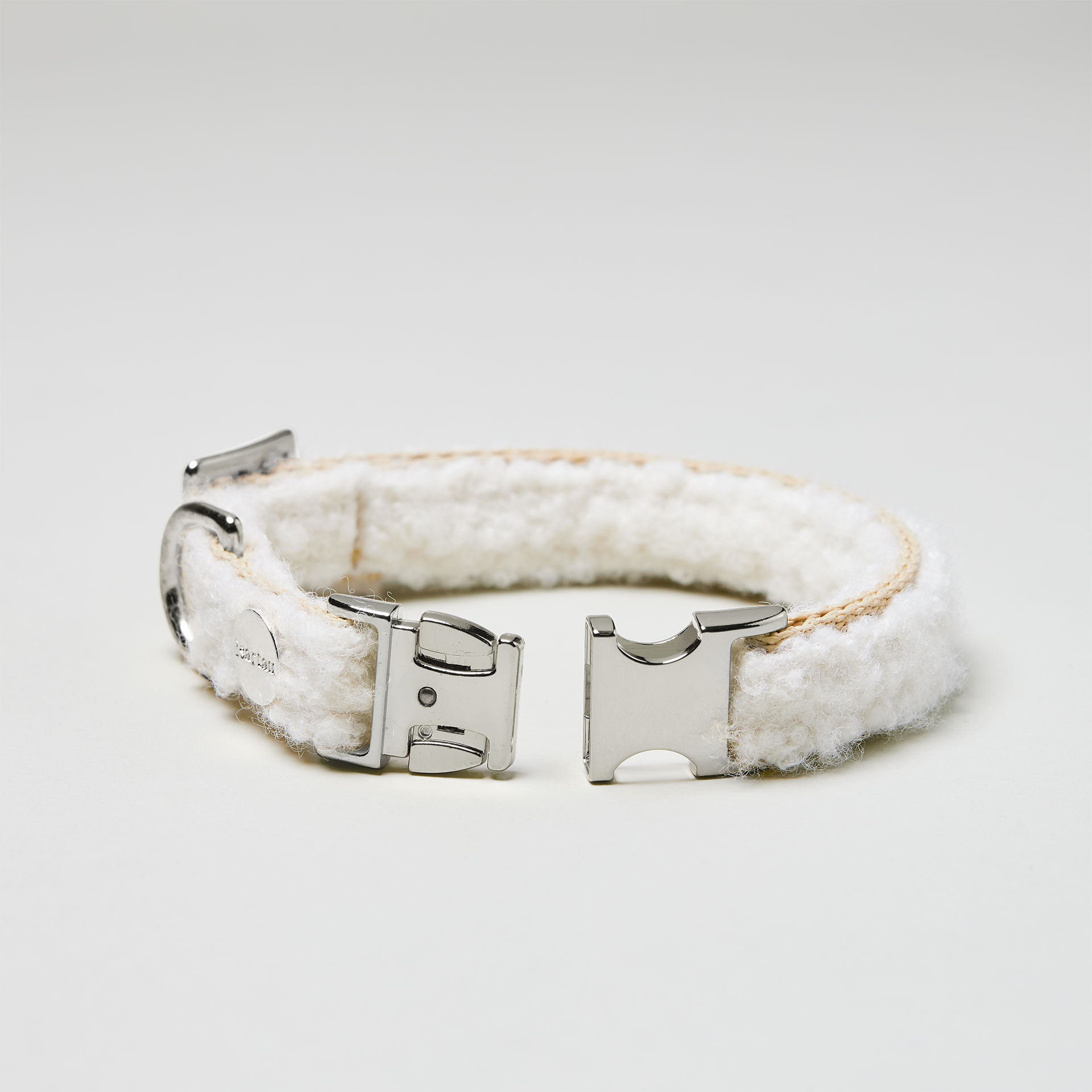 Detailaufnahme verstellbares Welpenhalsband Wooly mit offener silberfarbener Steckschließe, Gurtband beige mit weißem Bouclé Stoff