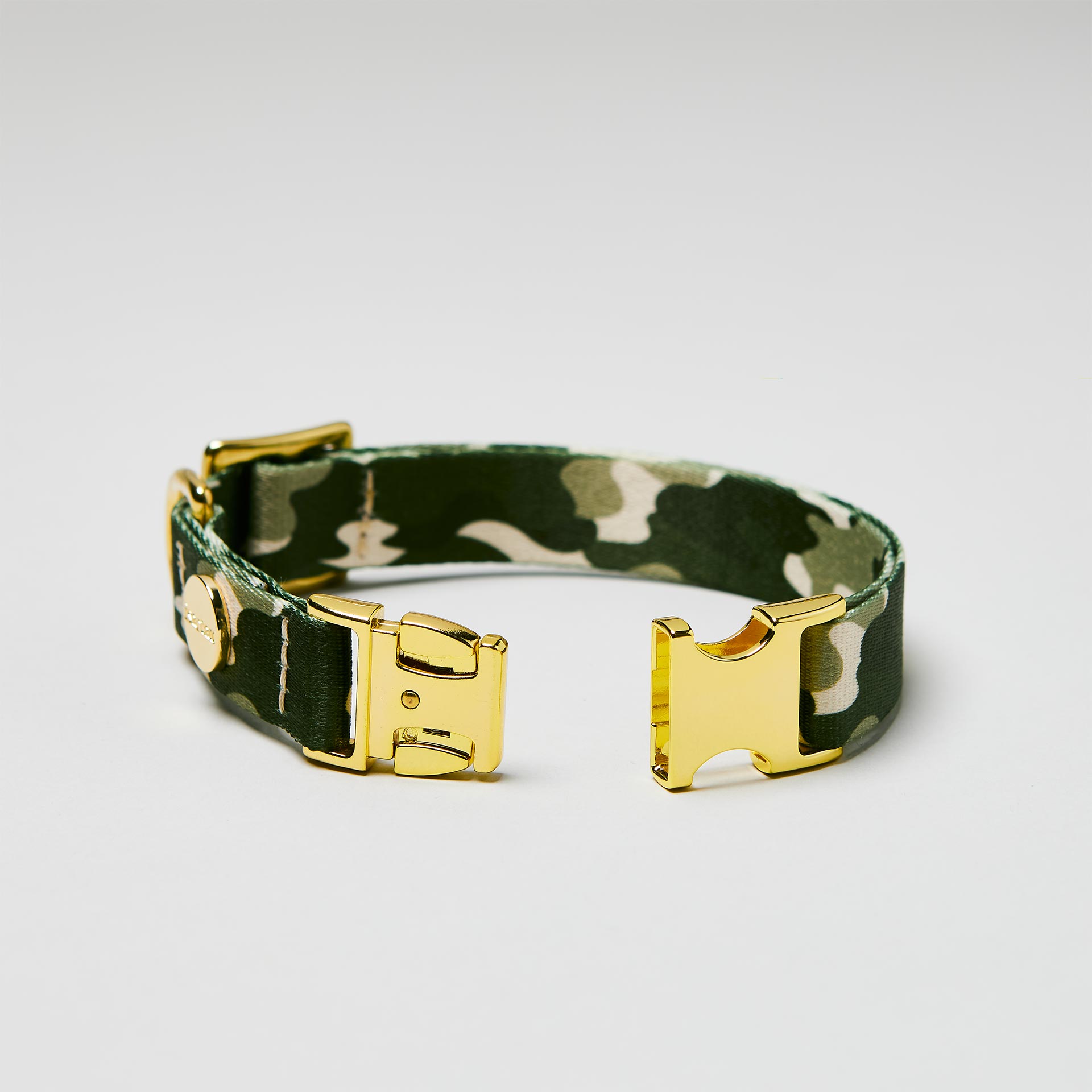 Detailaufnahme verstellbares Halsband „Entdecker“ mit offener goldfarbener Steckschließe, Gurtband im tarnfarbenen Stil.