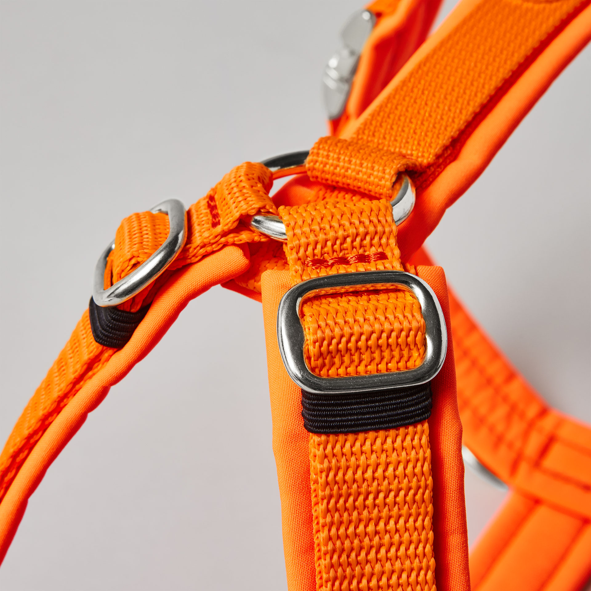 Silberfarbene verstellbare Schieber im Schulterbereich des neonorangen Hundegeschirrs