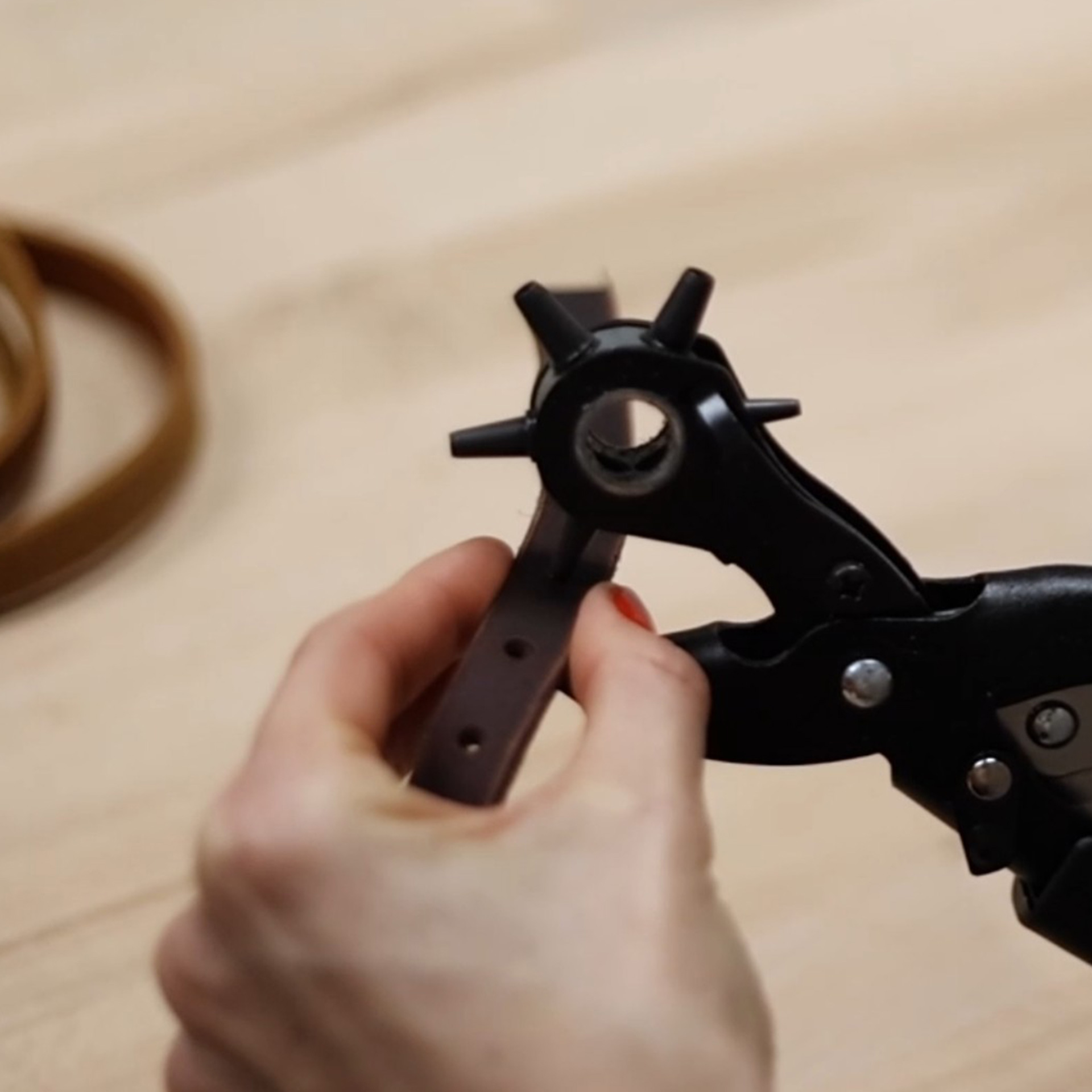 Leder wird mit Lochzange bearbeitet, Manufakturarbeit isartau