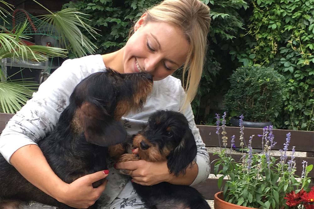 Dackelzüchterin kuschelt mit Dackeln