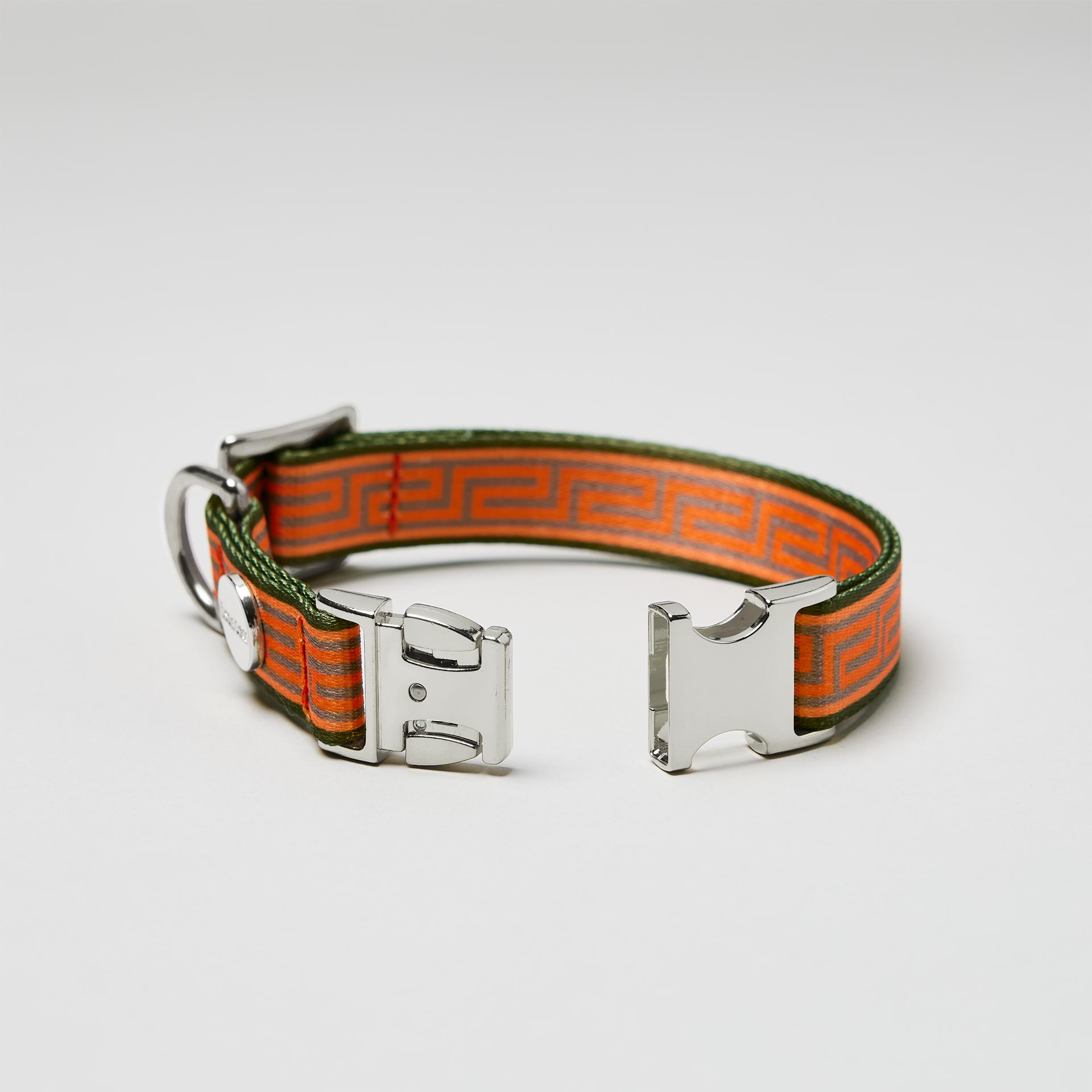 Detailaufnahme verstellbares Hundehalsband Wellenbrecher mit offener silberfarbener Steckschließe, Gurtband mit Mäander Muster Orange Oliv
