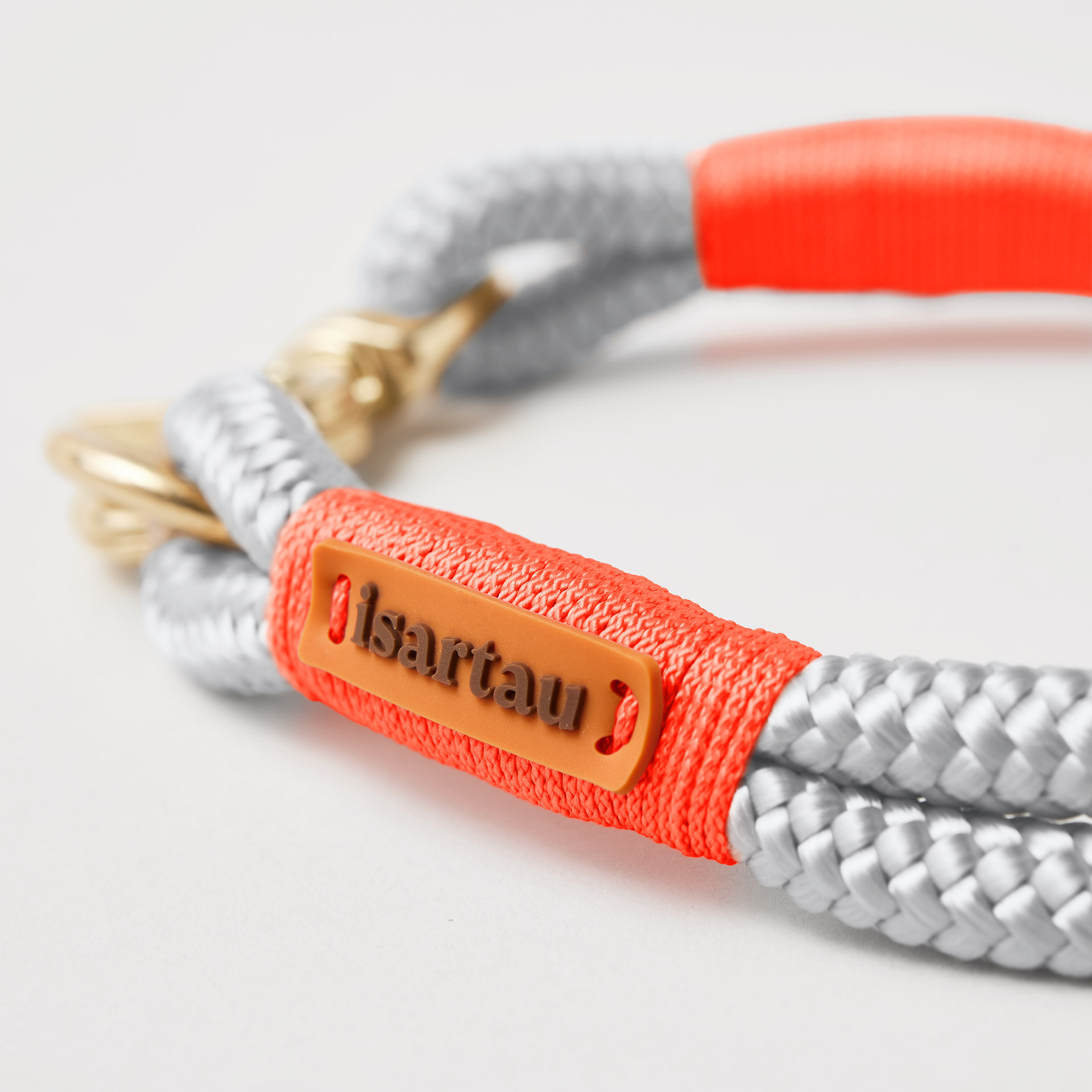 isartau Logo auf neonoranger Takel Softtau Pebble Stone Neonorange mit Messing-Beschlägen, hellgraues Tau mit neonoranger Takelung
