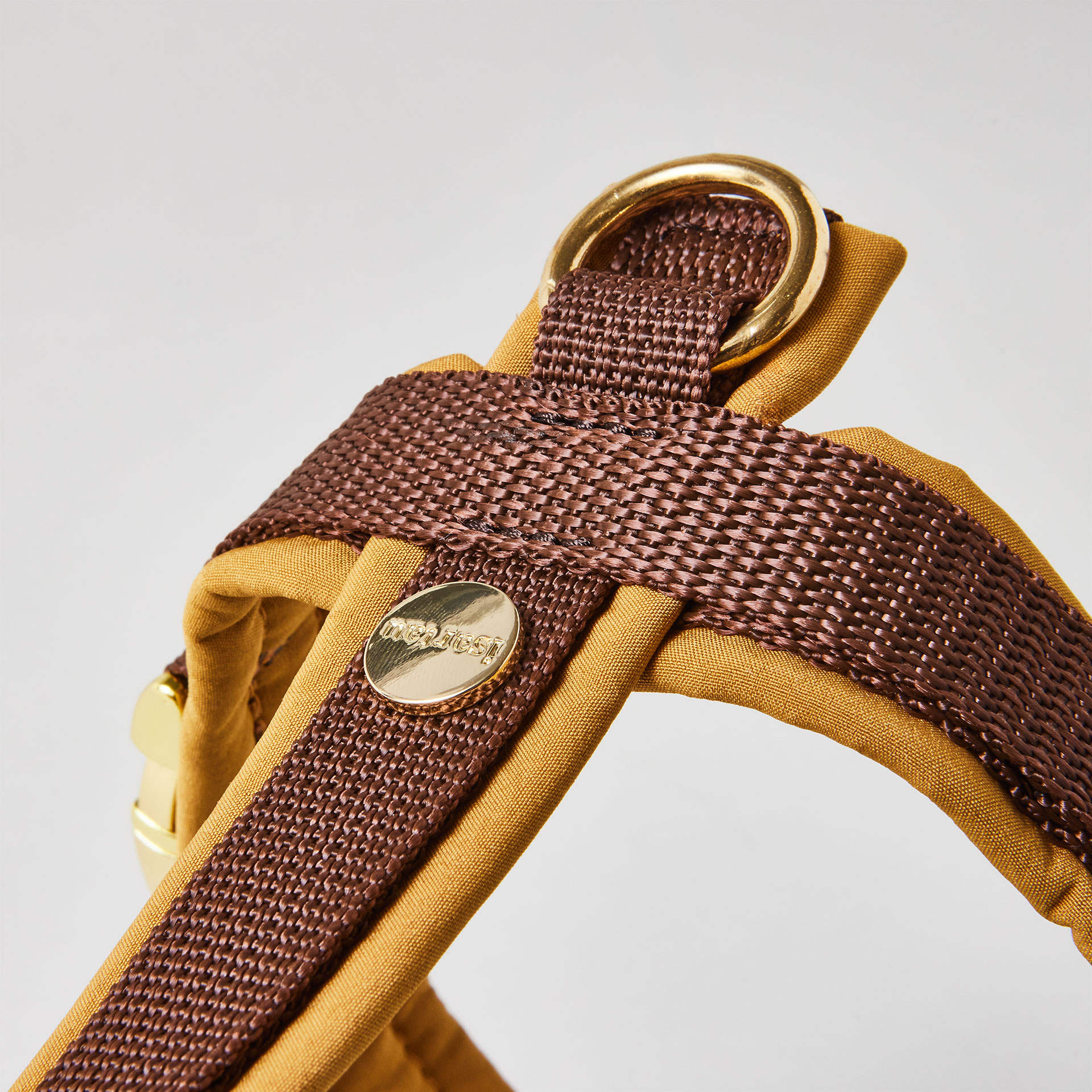 Rückenstück des zweifarbigen Hundegeschirrs Softie Karamell mit karamellfarbener Polsterung, braunem Gurtband, gepolstertem O-Ring und Logo-Niete, goldfarben