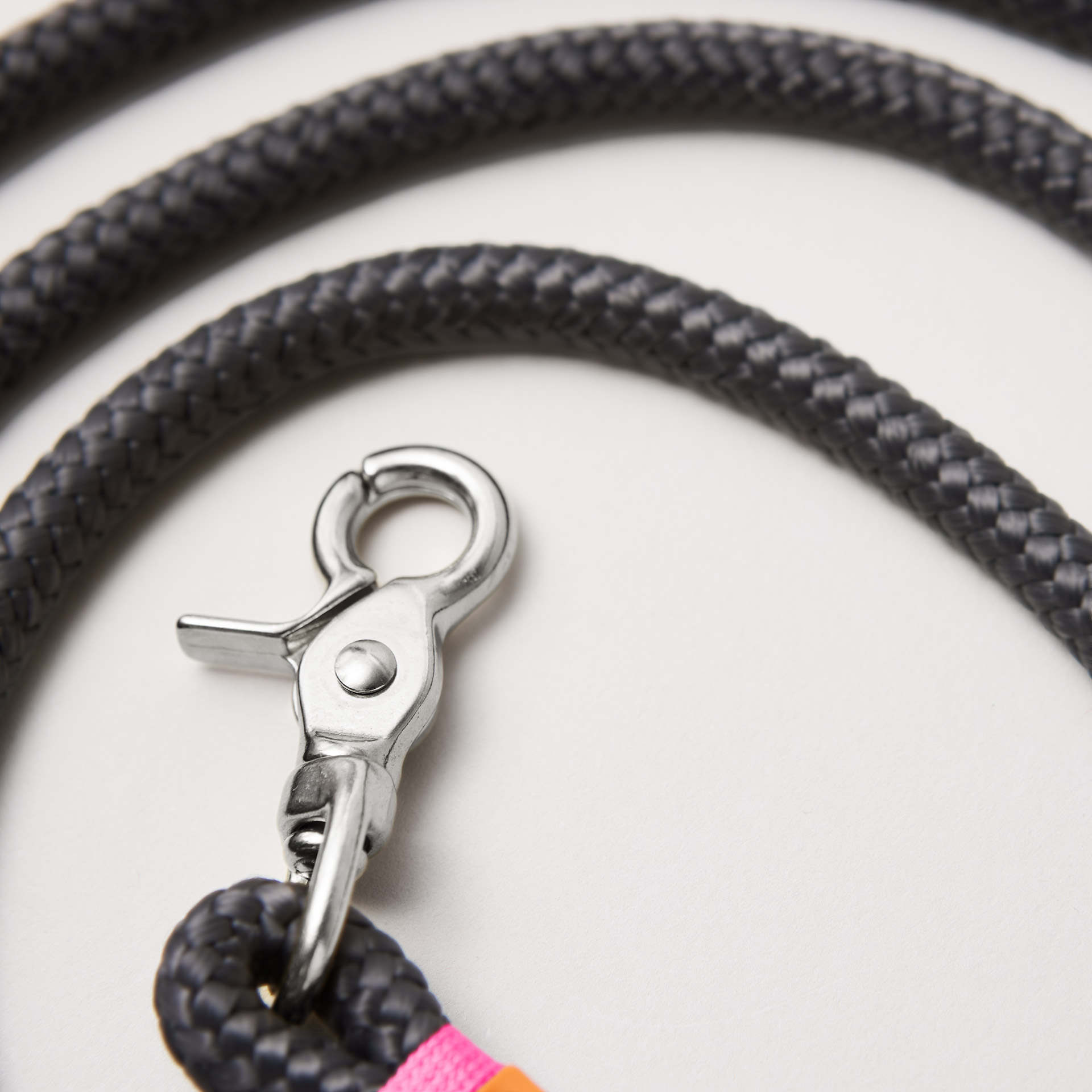 Detail Hundeleine Heavens Rock Neonpink, dunkelgraues Tau mit neonpinker Takelung, Fokus auf silberfarbene Karabiner und Tau