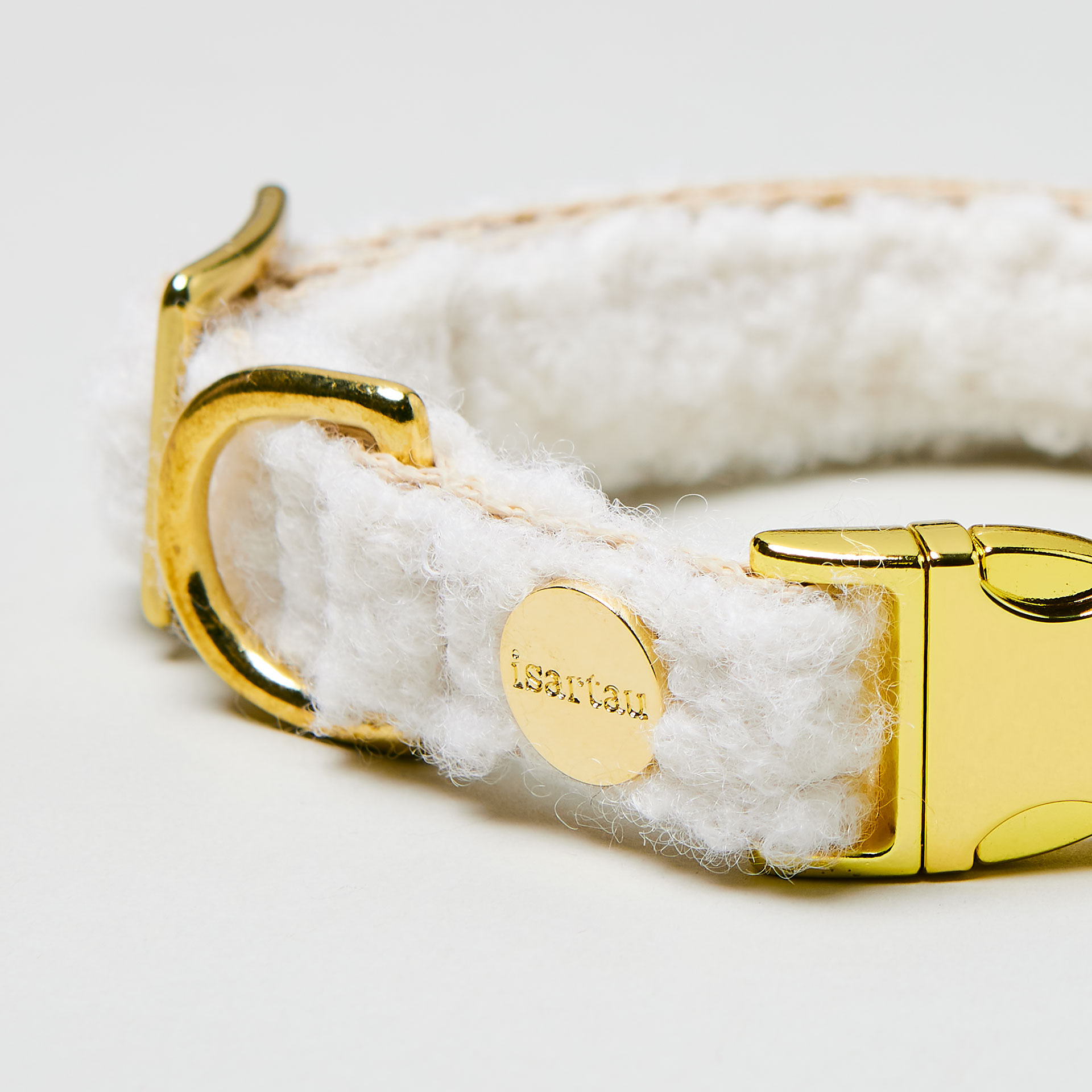 Nahaufnahme verstellbares Welpen Halsband Wooly mit weißem Bouclé Stoff auf beigem Gurtband, goldfarbene Steckschließe