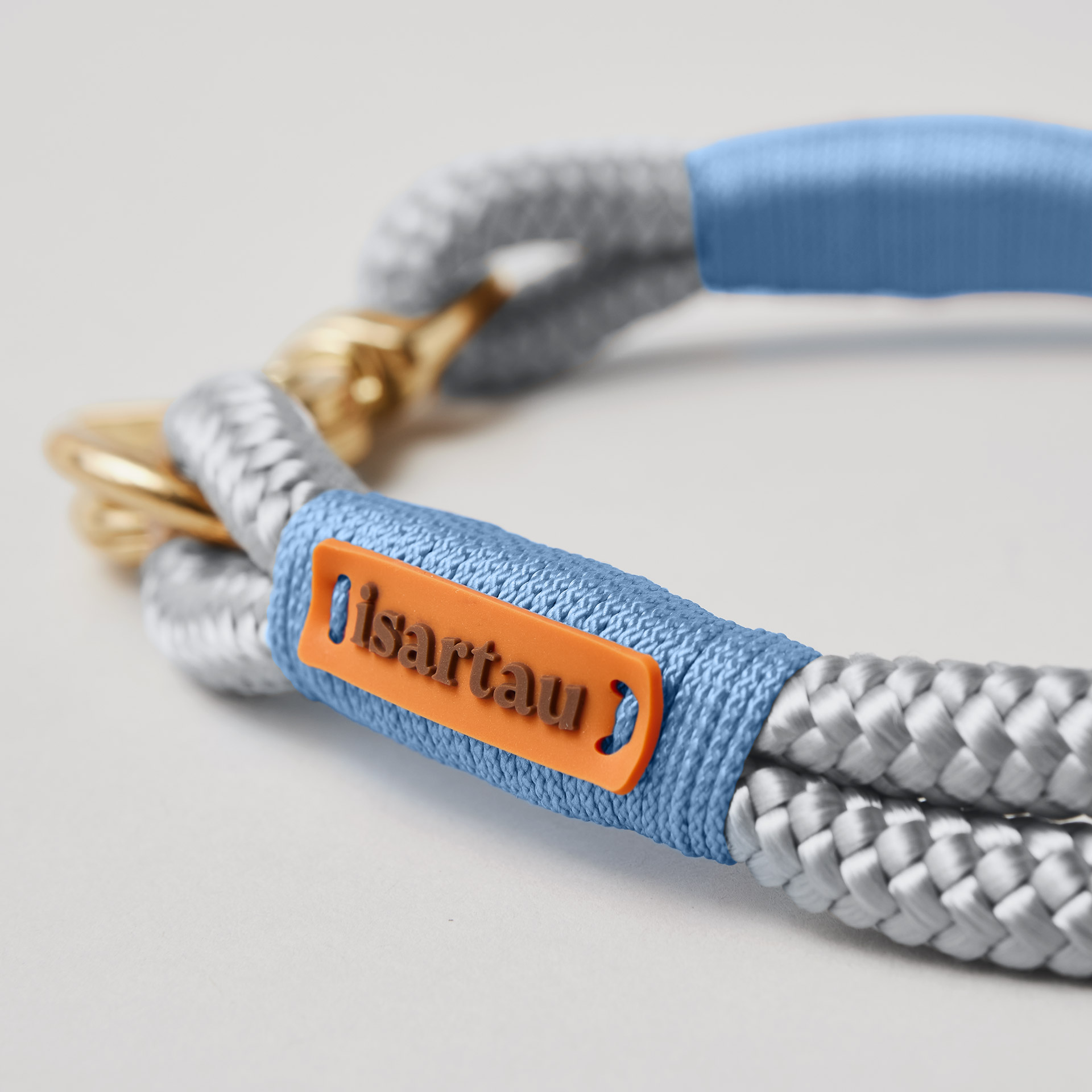 isartau Logo auf hellblauem Takel Softtau Pebble Stone Hellblau mit Messing-Beschlägen, hellgraues Tau mit hellblauer Takelung
