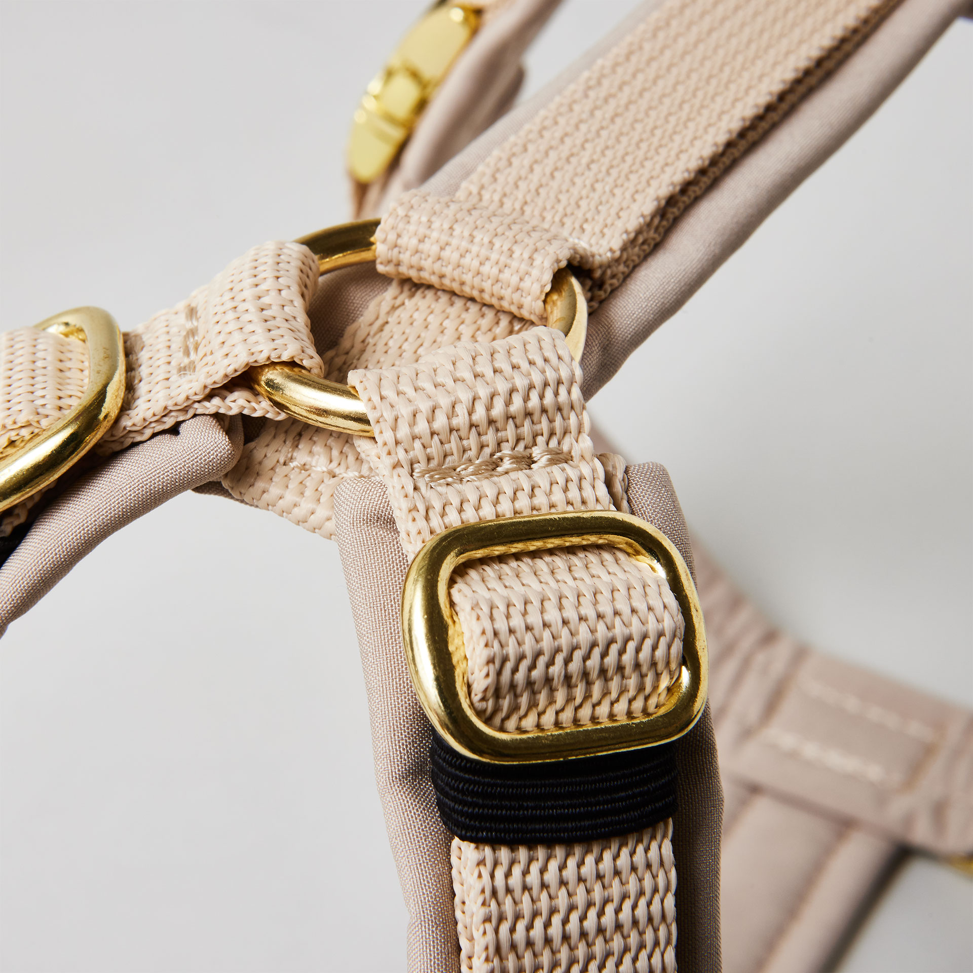 Goldfarbene verstellbare Schieber im Schulterbereich des beigen Hundegeschirrs.