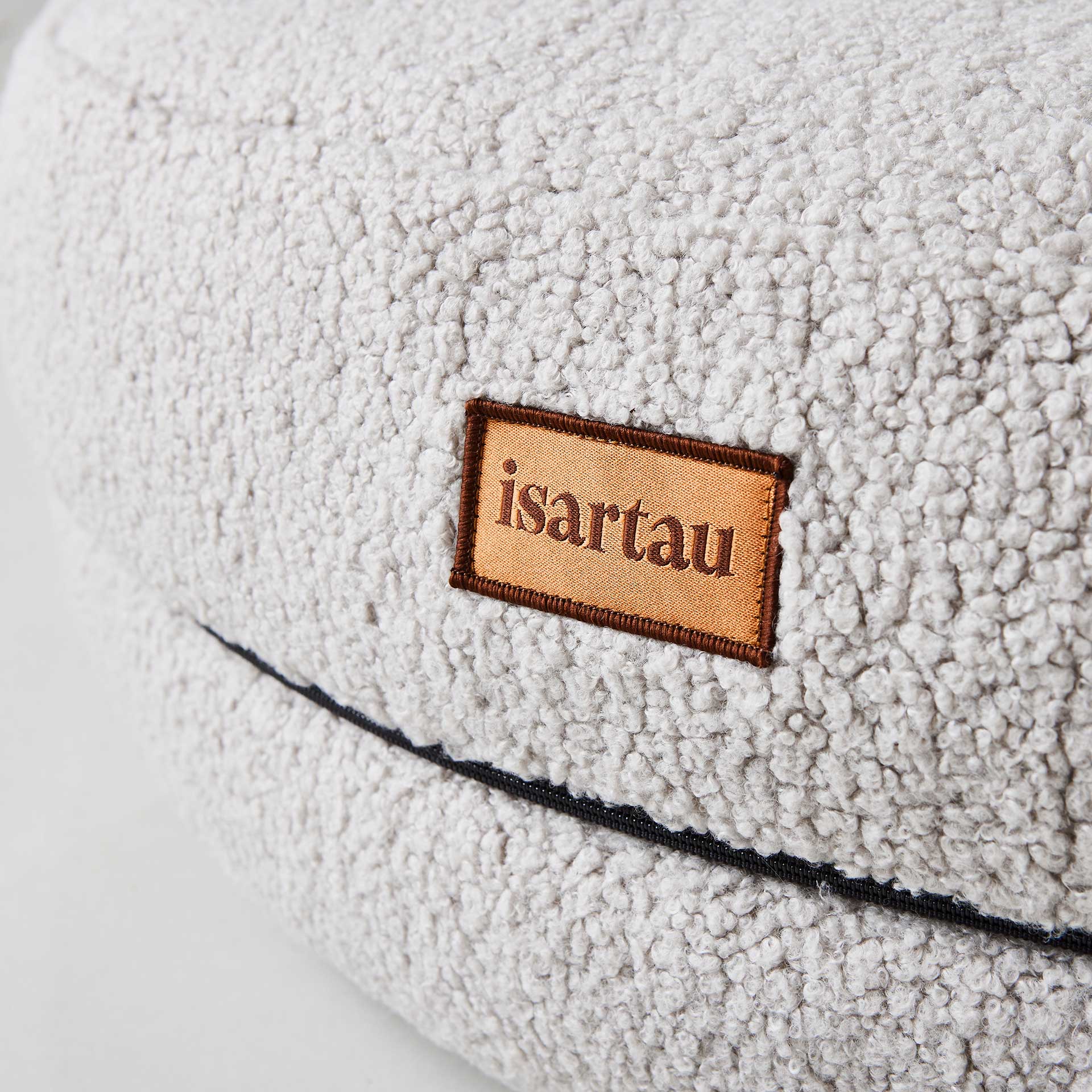 Detail Hundebett Bagelbettchen mit abnehmbarem hellgrauer Teddystoffbezug, Fokus auf isartau Logo
