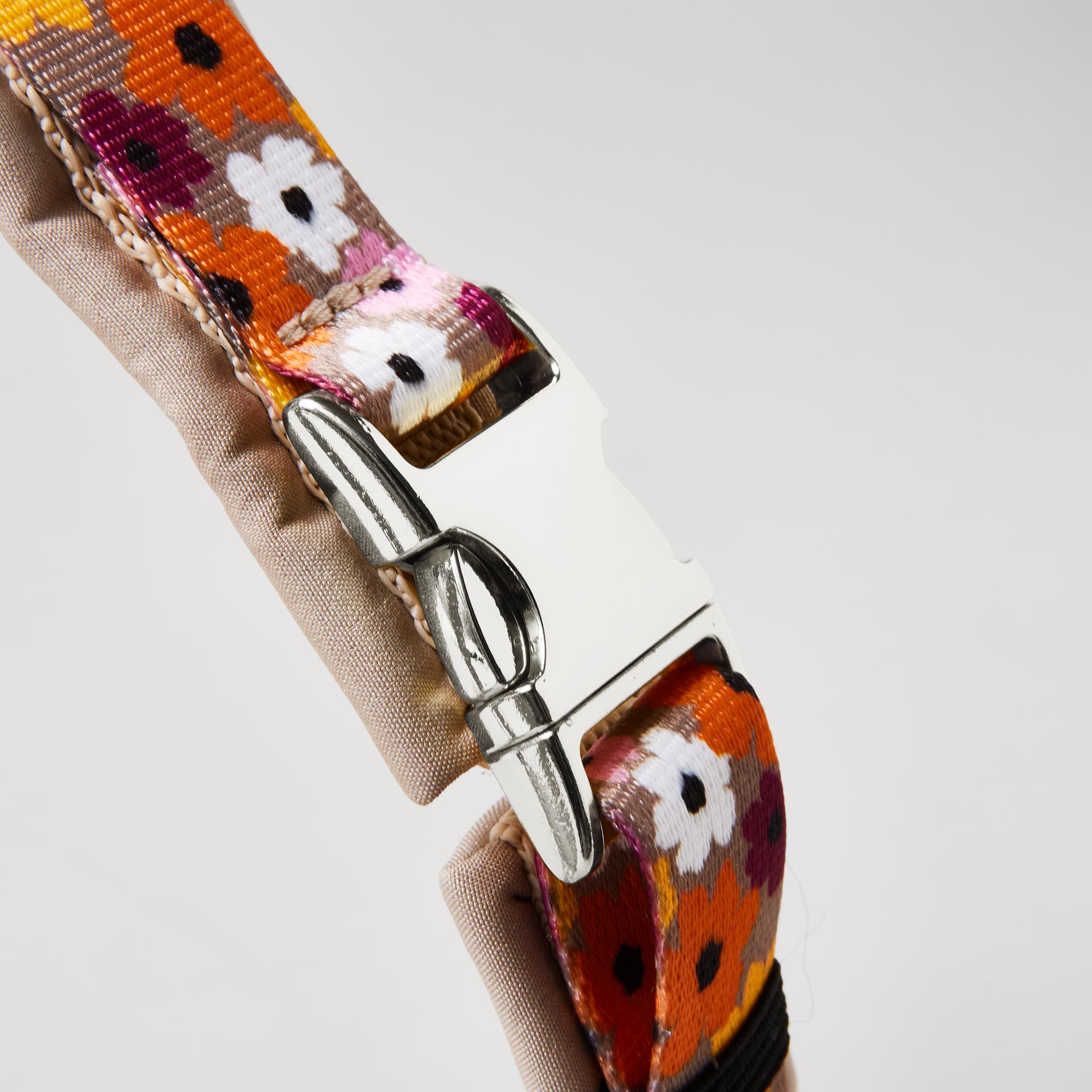 Detail gepolstertes Hundegeschirr „Blumenmeer“ mit silberfarbener Steckschließe zum Öffnen und Schließen.