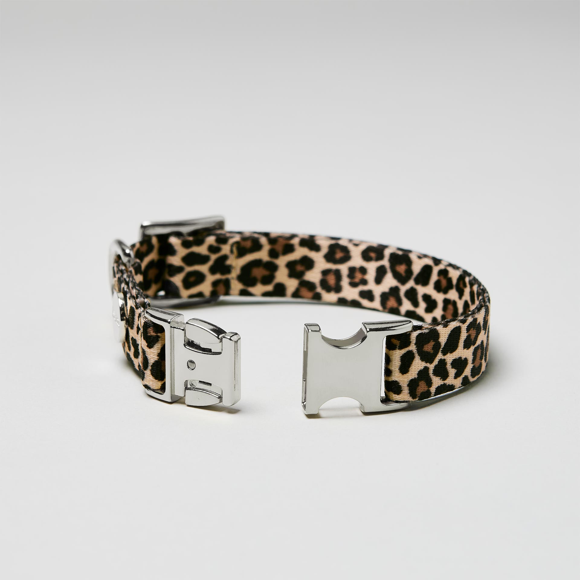 Detailaufnahme verstellbares Welpenhalsband Leo mit offener silberfarbener Steckschließe, Gurtband mit Leoprint