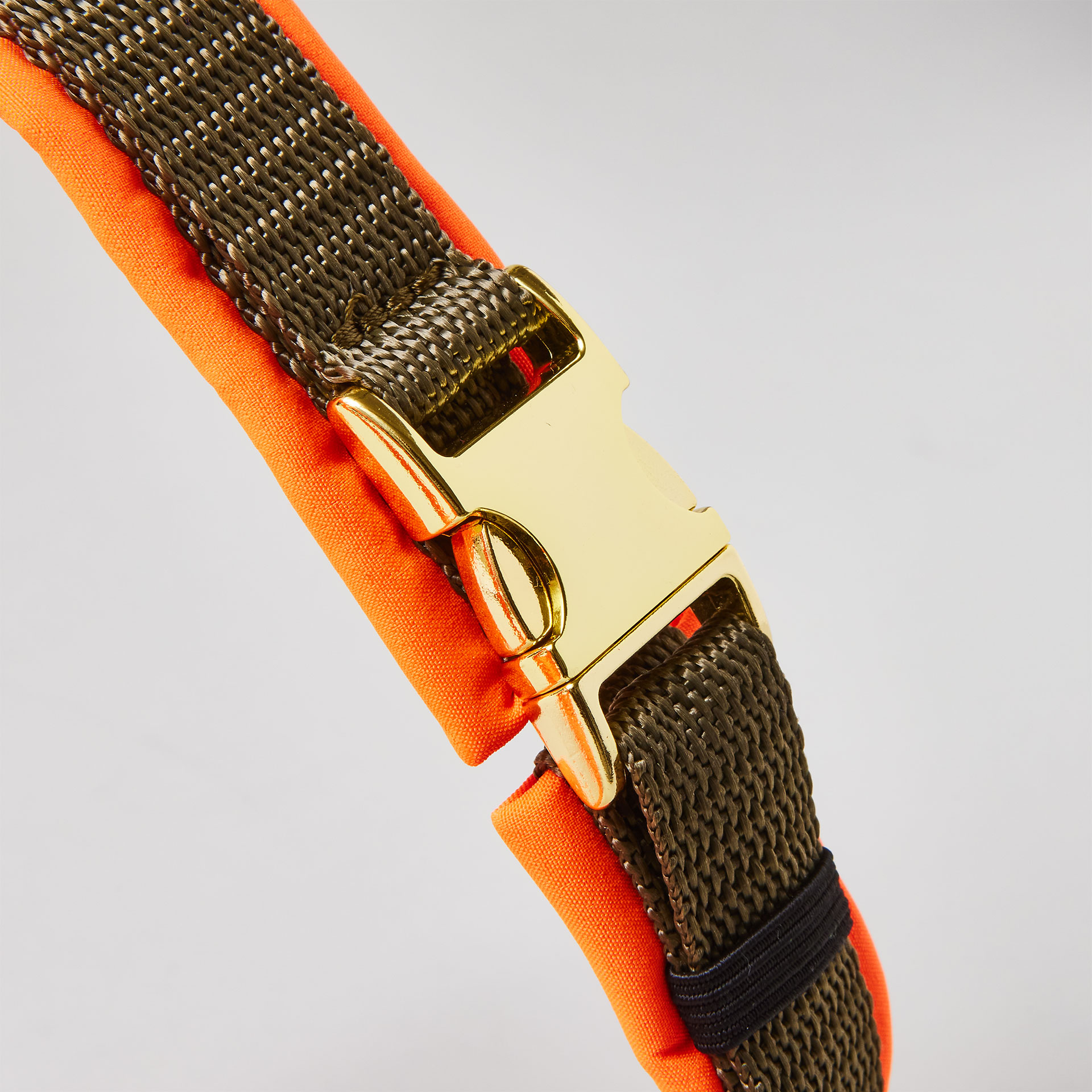 Goldfarbene verstellbare Schieber im Schulterbereich des zweifarbigen Hundegeschirrs Softie Neonorange Oliv mit olivfarbenem Gurtband und neonoranger Polsterung