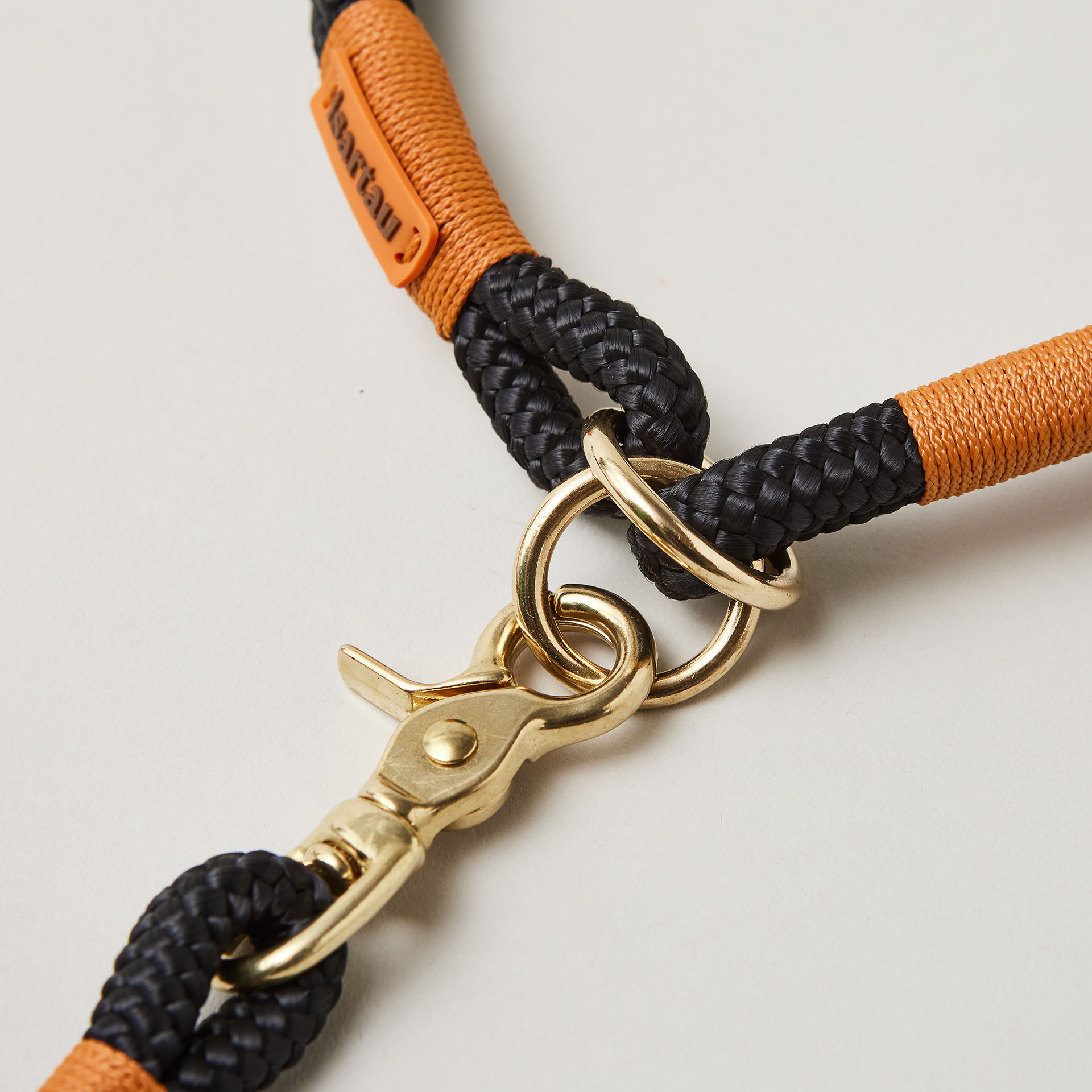 Detail Zugstopp Halsband mit Tauleine Black Mamba Rost Orange, schwarzes Tau mit rost-oranger Takelung Fokus auf Messingringe und Karabiner
