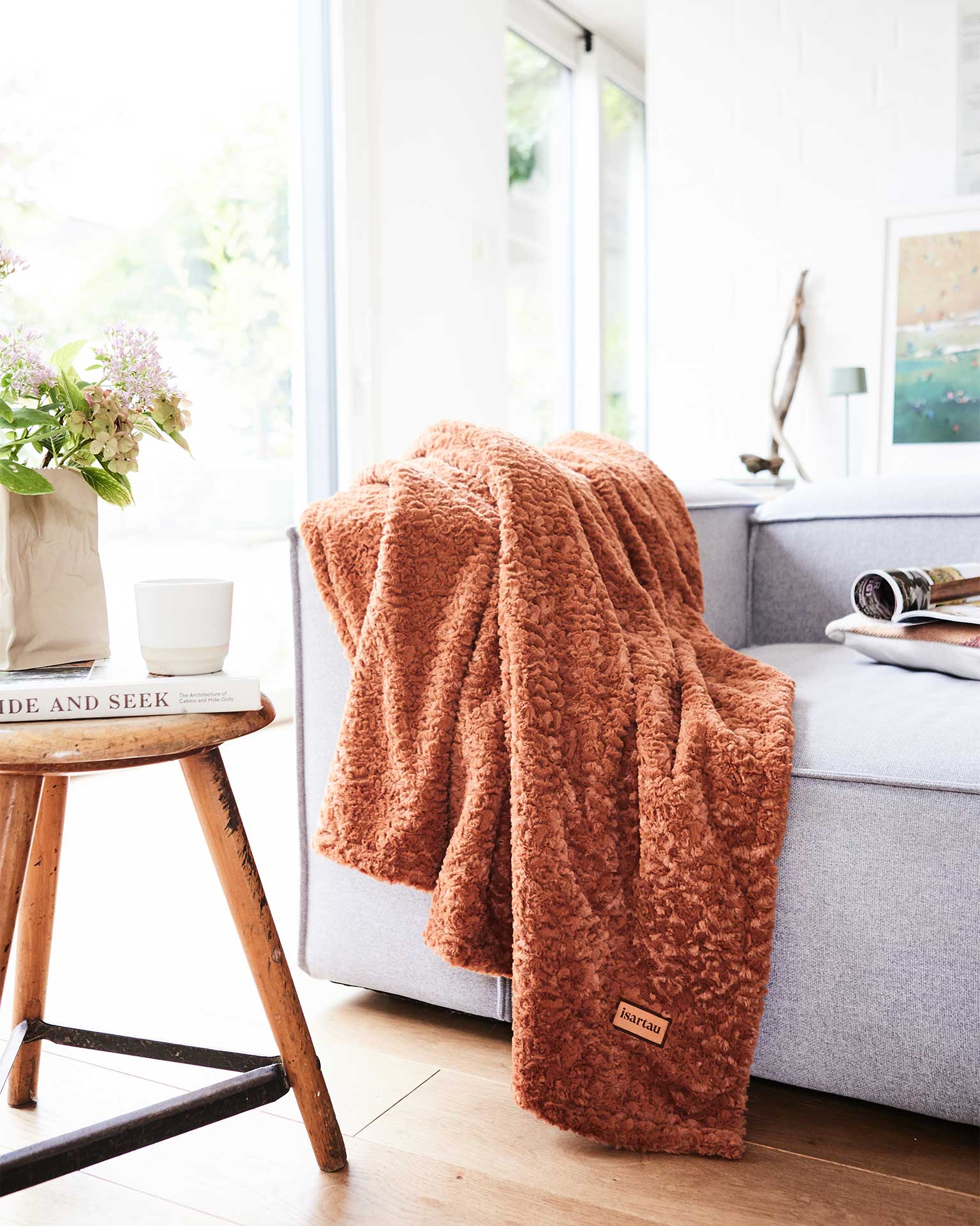 Zimtfarbene Wohndecke auf grauer Couch in Wohnzimmer, Größe 190x150 cm