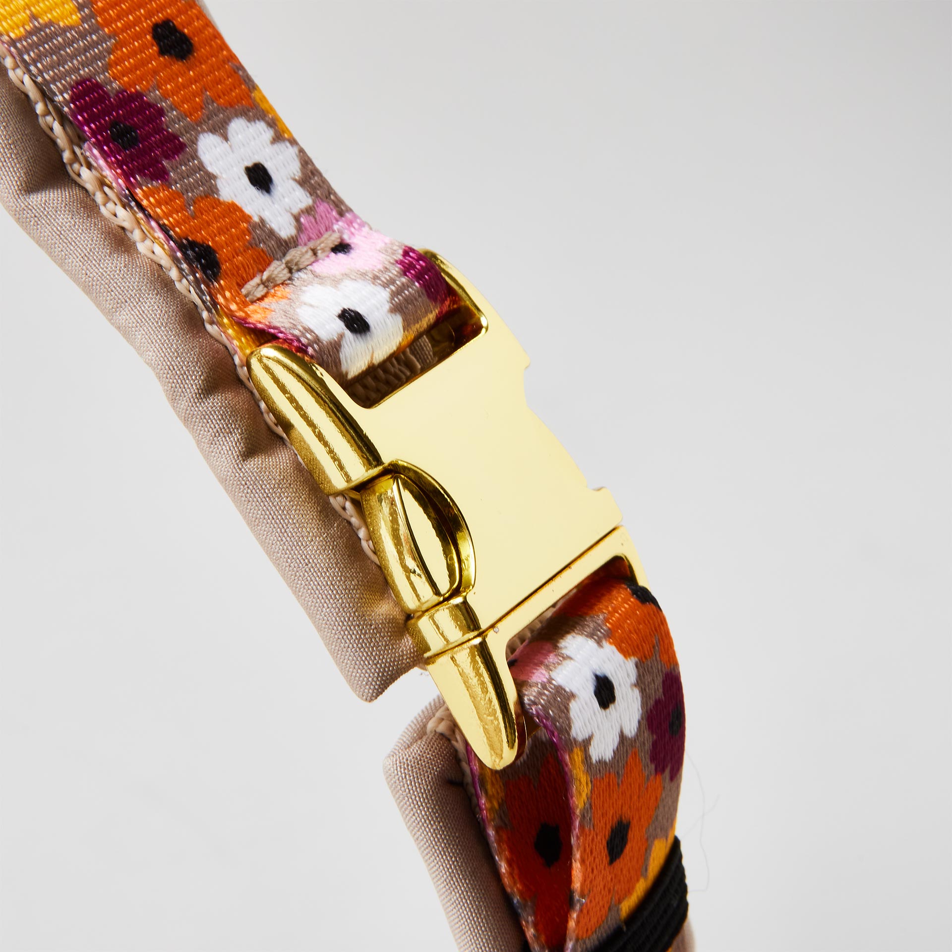 Detail gepolstertes Hundegeschirr „Blumenmeer“ mit goldfarbener Steckschließe zum Öffnen und Schließen, florales Gurtband.