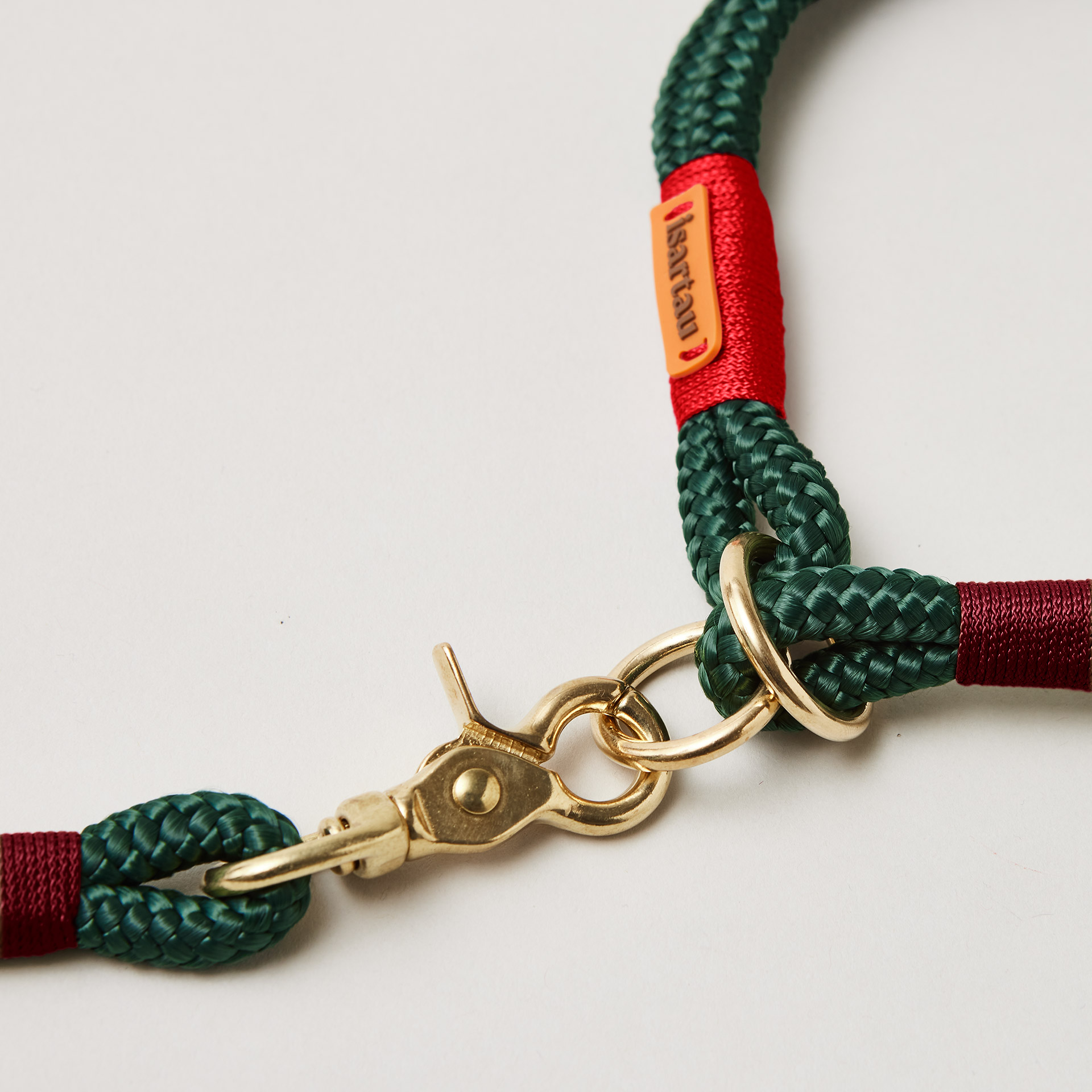 Detail Zugstopp Halsband mit Tauleine Evergreen Rot Burgunder, dunkelgrünes Tau mit roter und burgunderfarbener Takelung Fokus auf Messingringe und Karabiner