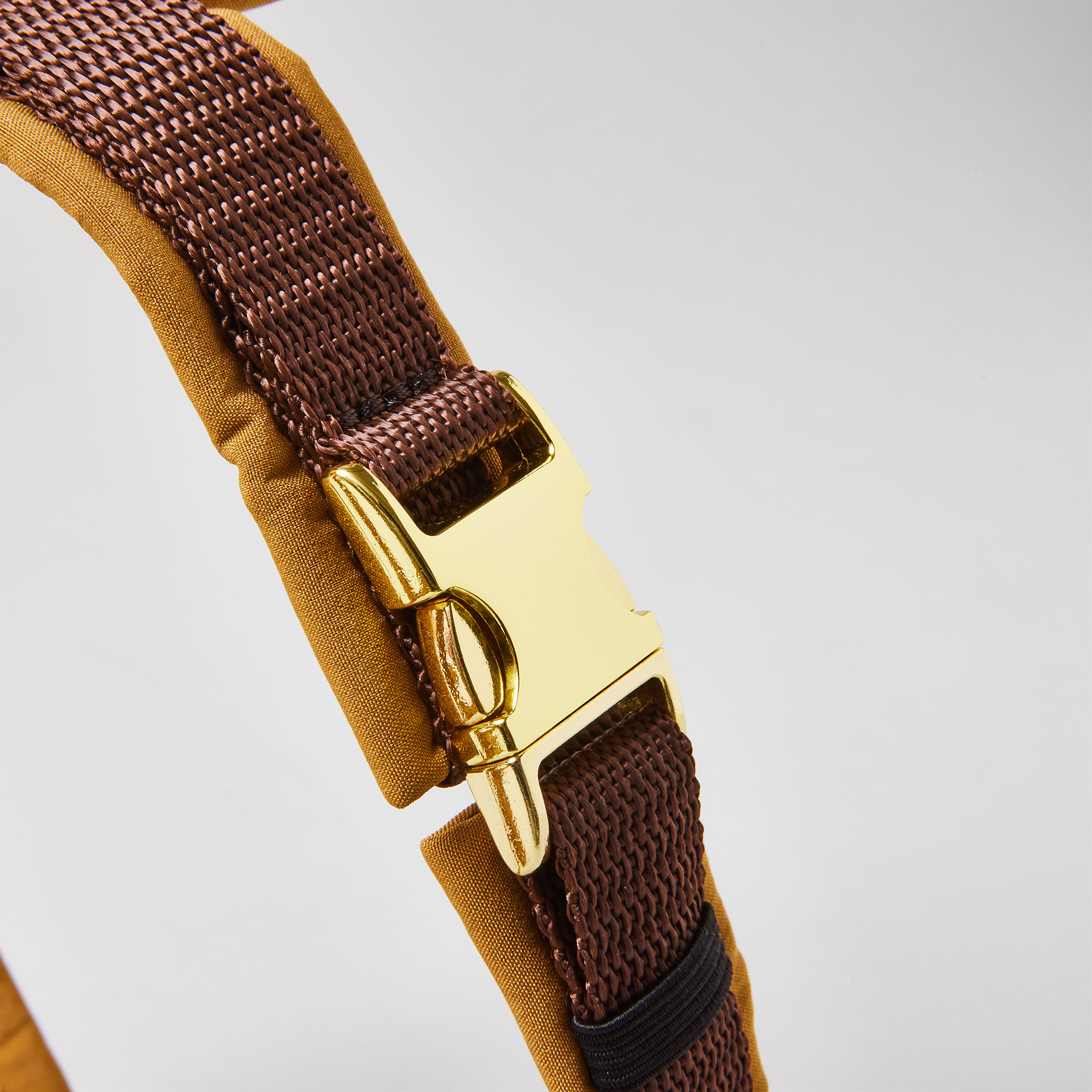 Verstellbare goldfarbene Steckschließe am braunen Bauchgurt des Hundegeschirrs Softie Karamell mit karamellfarbener Softshell-Polsterung