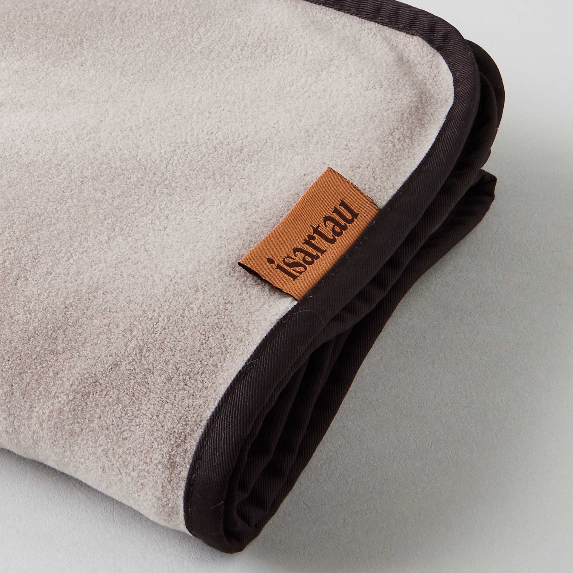 Detailbild Schmusedecke Beige mit dunkelbrauner Einfassung, isartau Logo