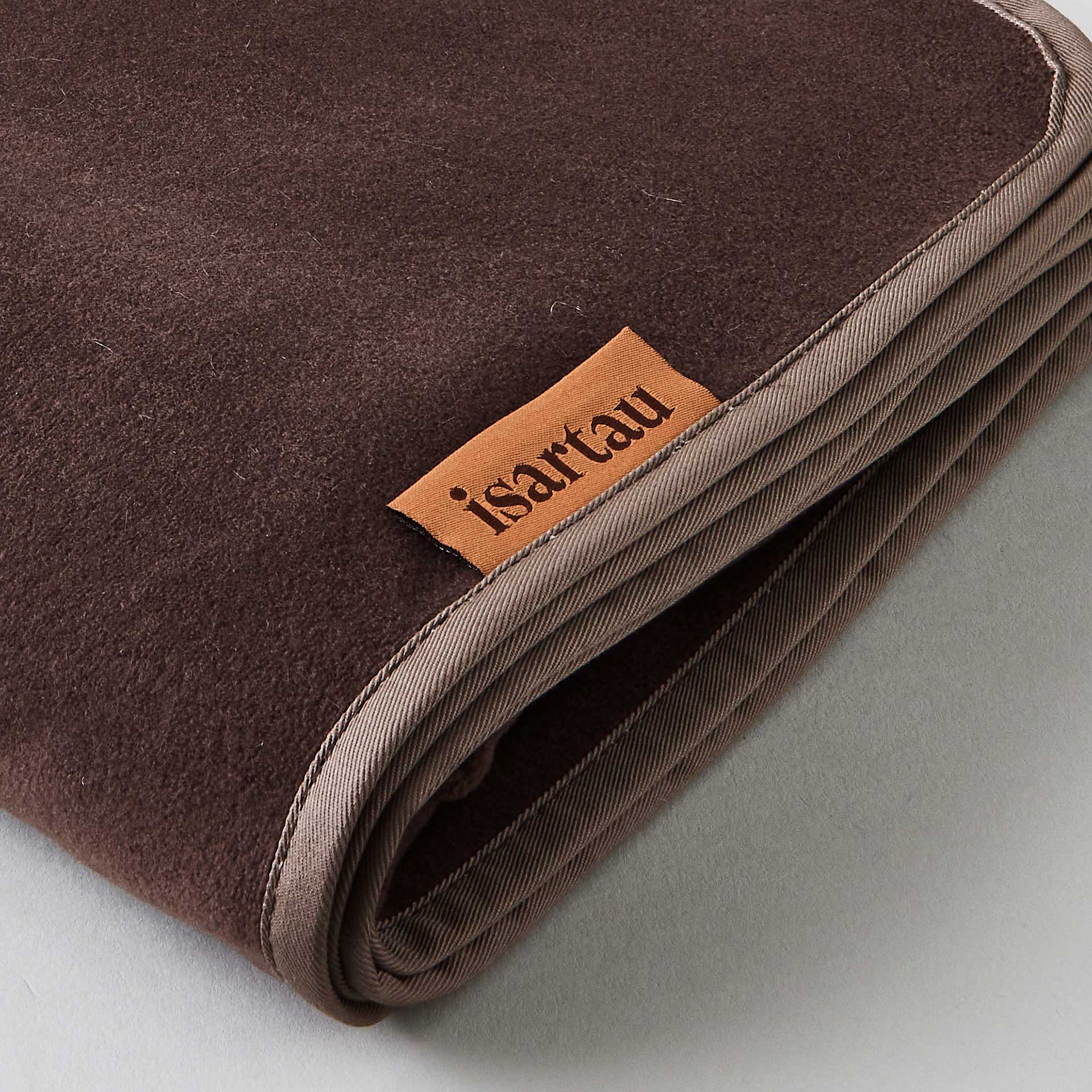 Detailbild Schmusedecke Beige mit dunkelbrauner Einfassung, isartau Logo