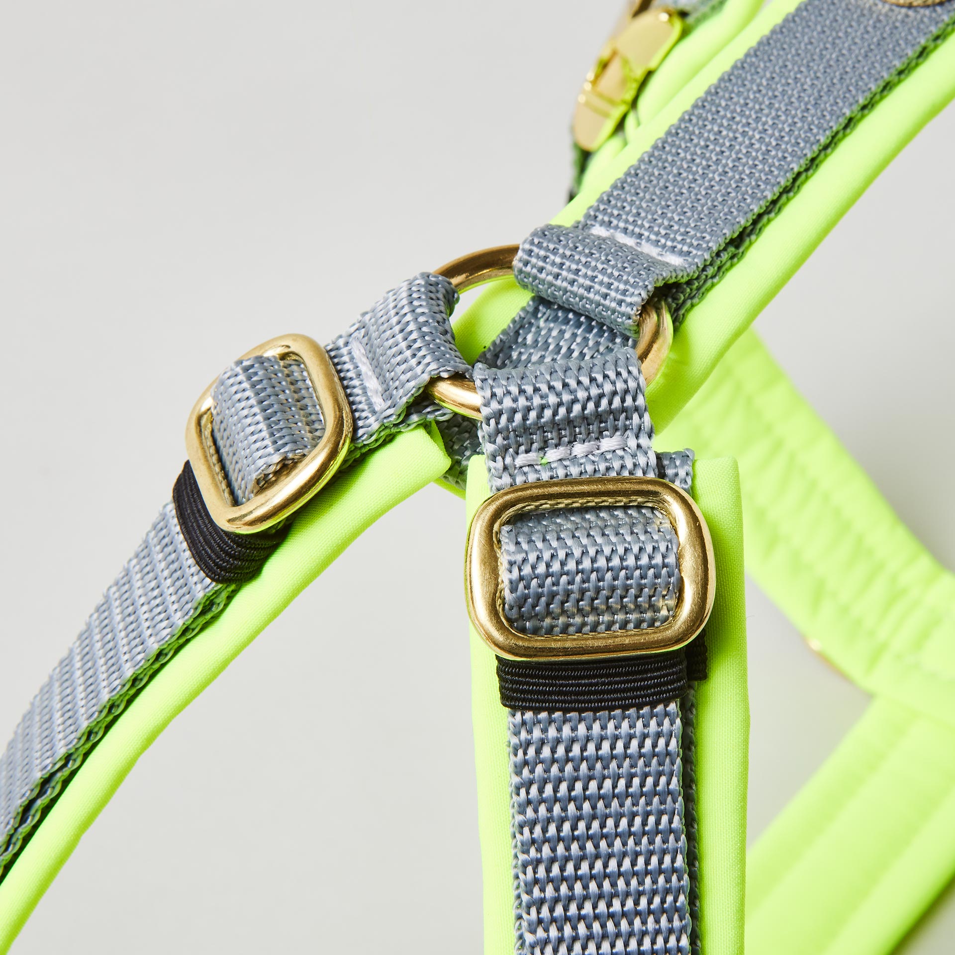 Goldfarbene verstellbare Schieber im Schulterbereich des zweifarbigen Hundegeschirrs Softie Neongelb Grau mit grauem Gurtband und neongelber Polsterung