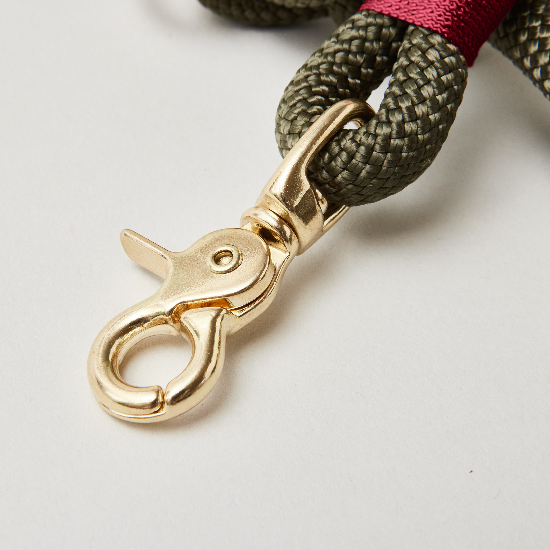 olivfarbenes Kletterseil mit burgunderfarbener Takelung, Fokus auf goldenen Scherenkarabiner