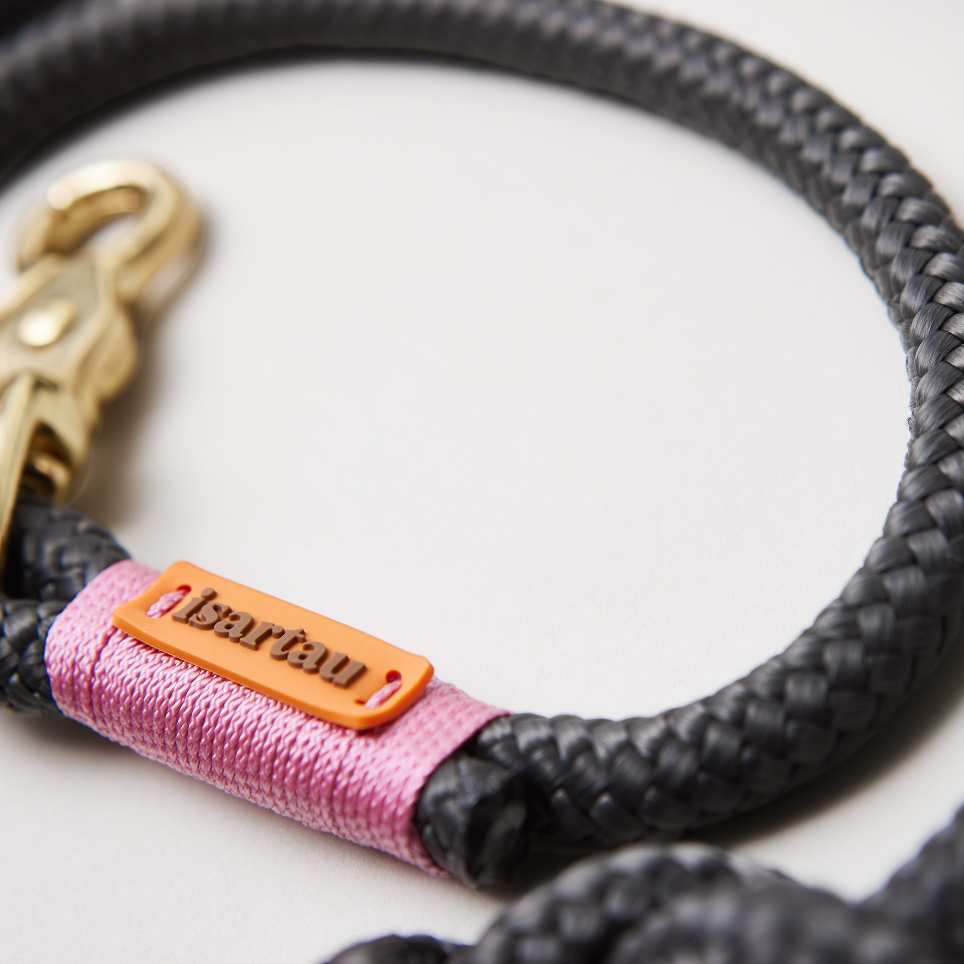 Detail isartau-Logo, feine Gravur auf dunkelgrauem Tau und rosafarbener Takelung